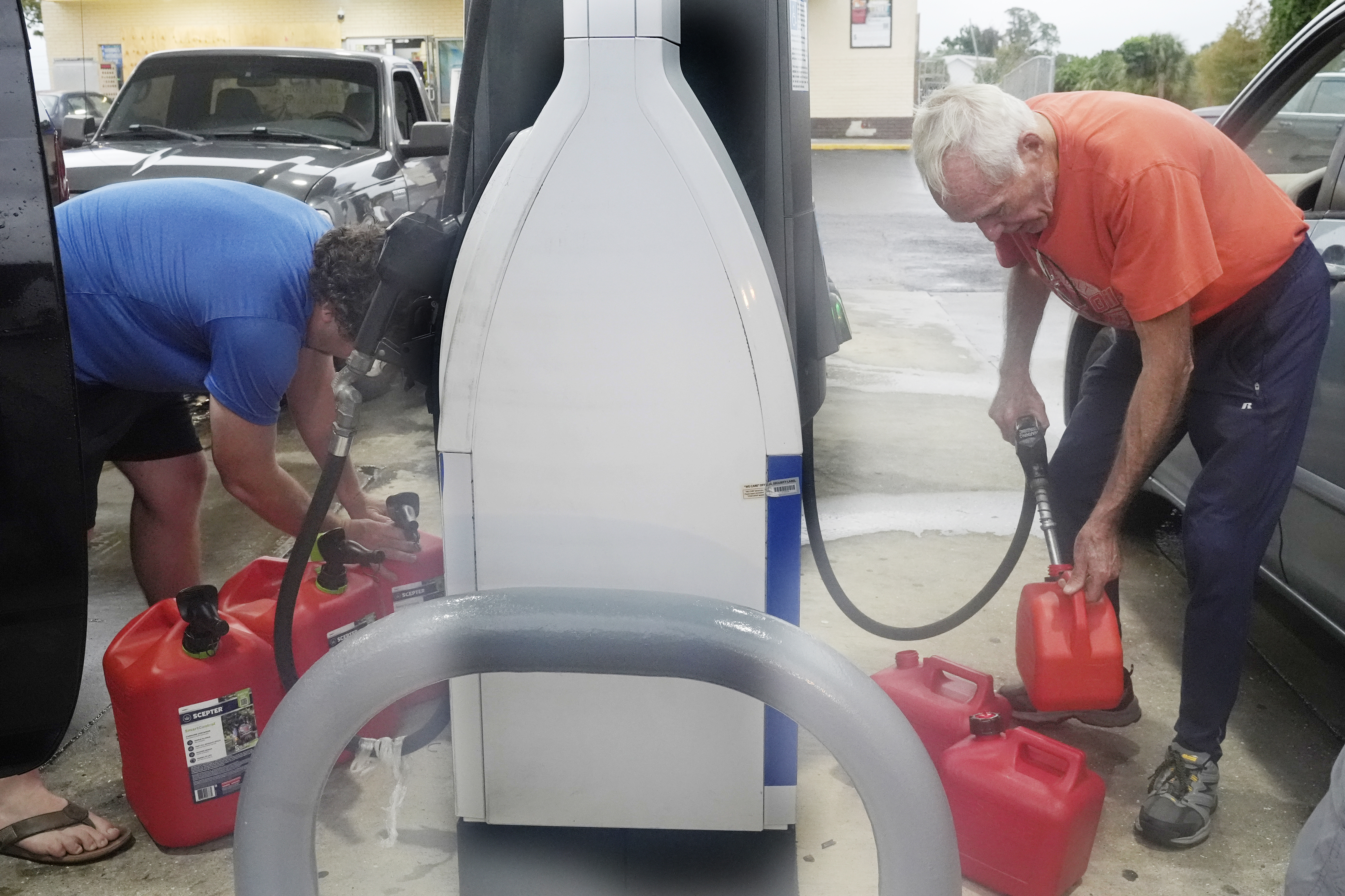 Don Hallenbeck, right, fills gas tanks as he prepares to stay in his home in advance of Hurricane Milton, Wednesday, Oct. 9, 2024, in Port Charlotte, Fla