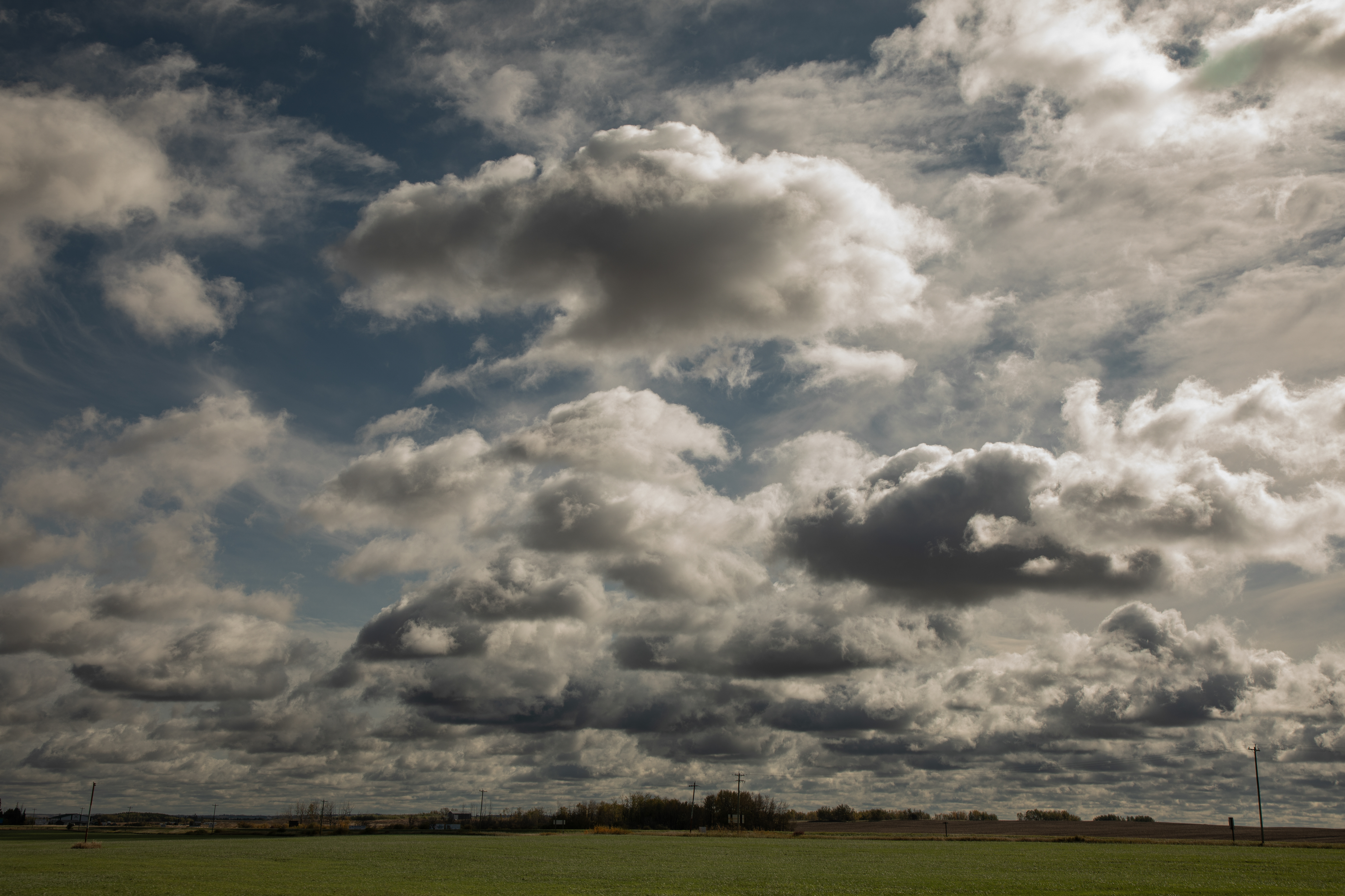 Clouds above a green field