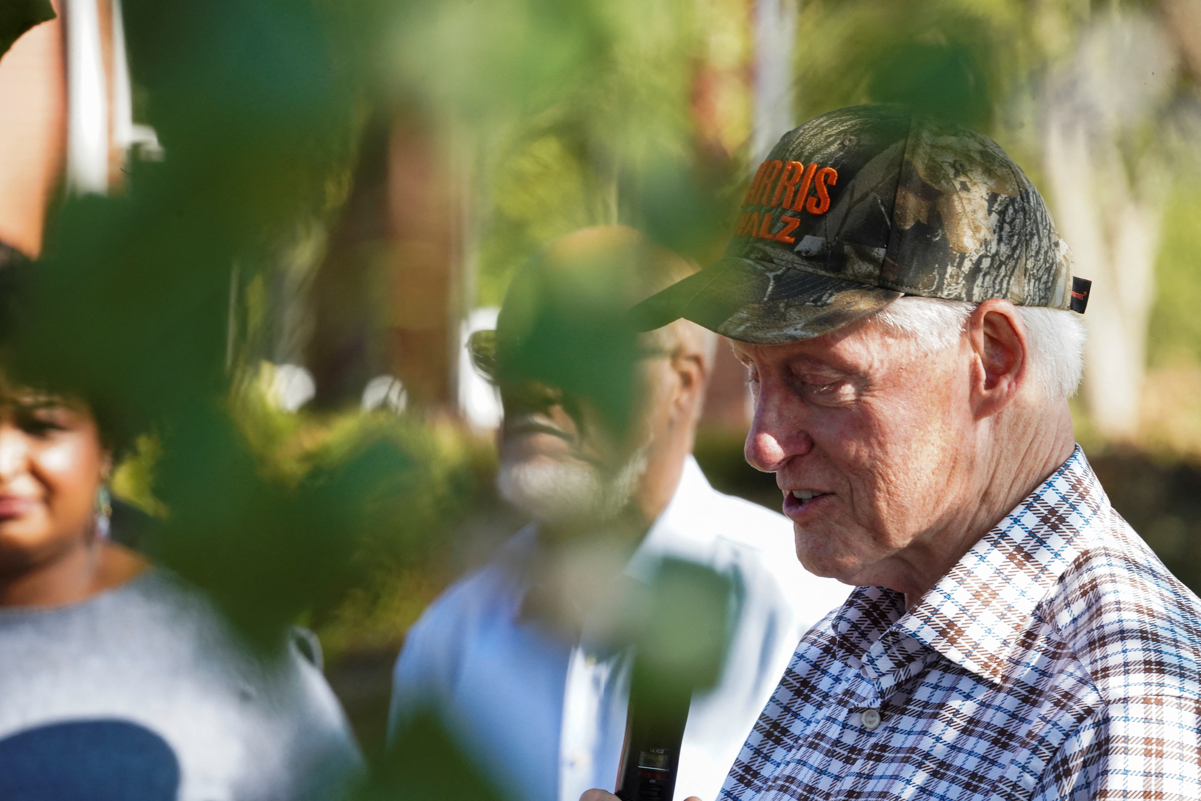 Bill Clinton, seen outdoors, behind the greenery of trees in the US state of Georgia