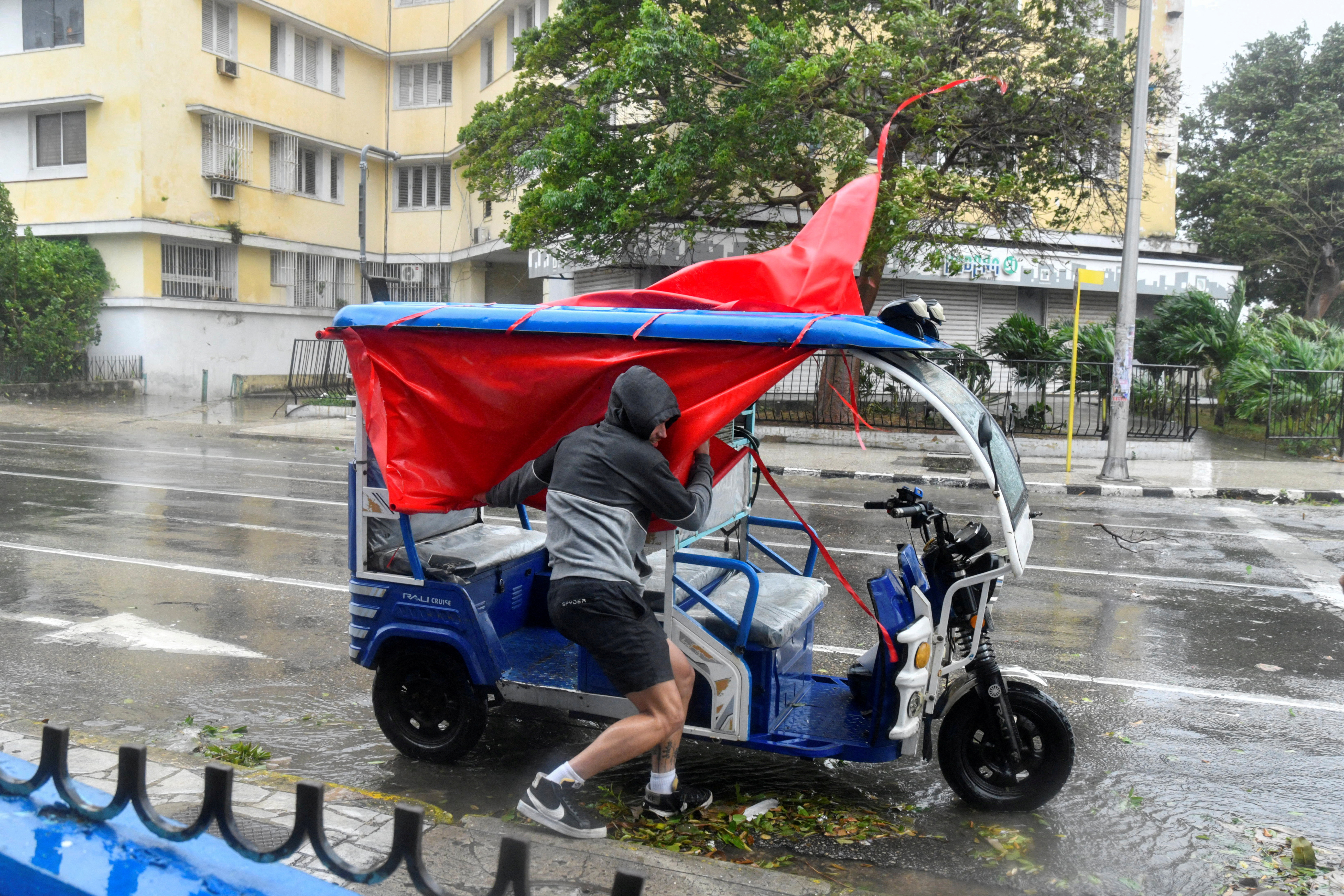 A small vehicle's fabric roof collapses in the rain