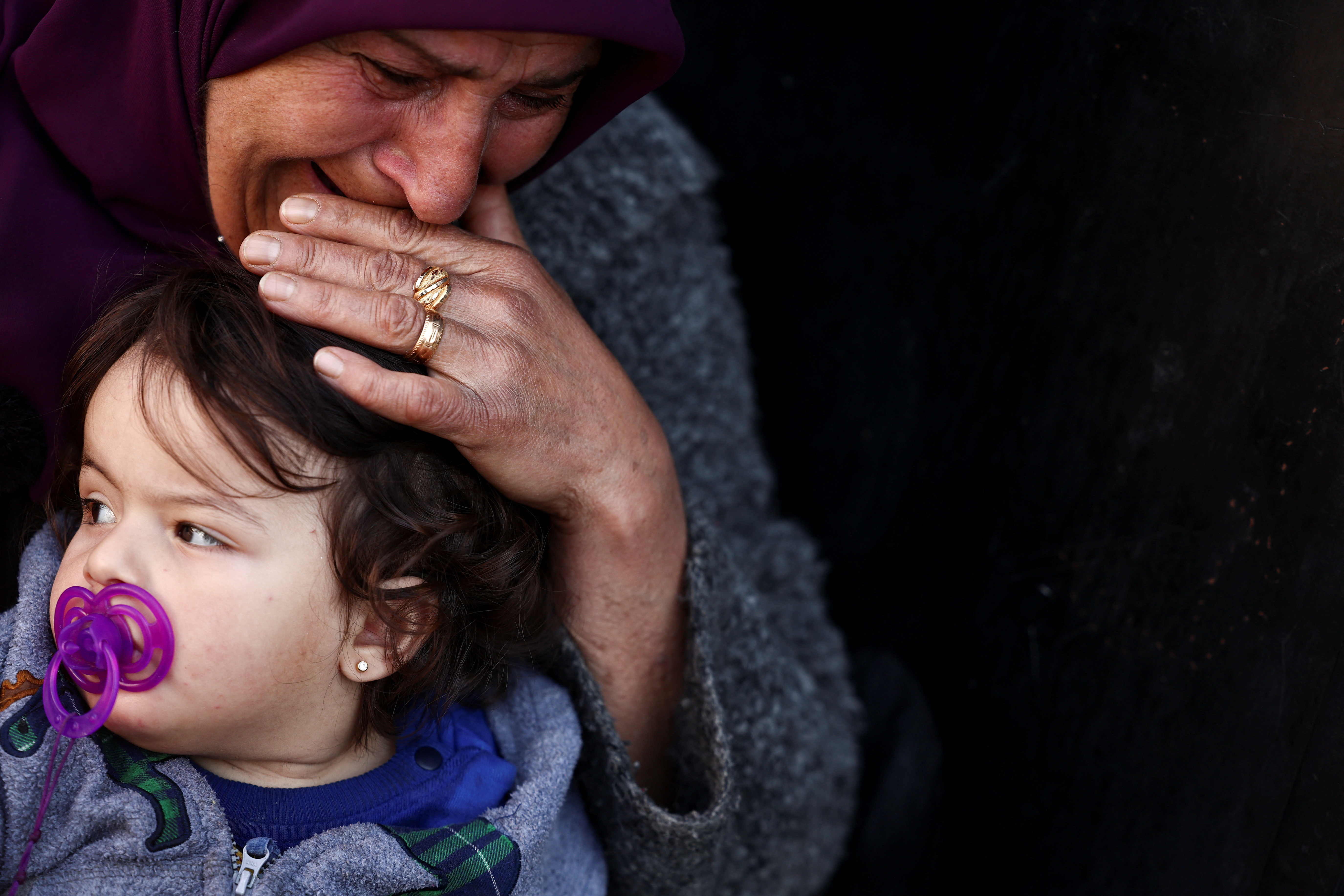 Rahife Hamiye Taraya, 85-year-old displaced woman, cries as she sits with a child in a school turned into a shelter for displaced people, where Relief International staff are providing healthcare and wellbeing services on-site, in the West Bekaa, Lebanon, November 7, 2024. REUTERS/Yara Nardi TPX IMAGES OF THE DAY