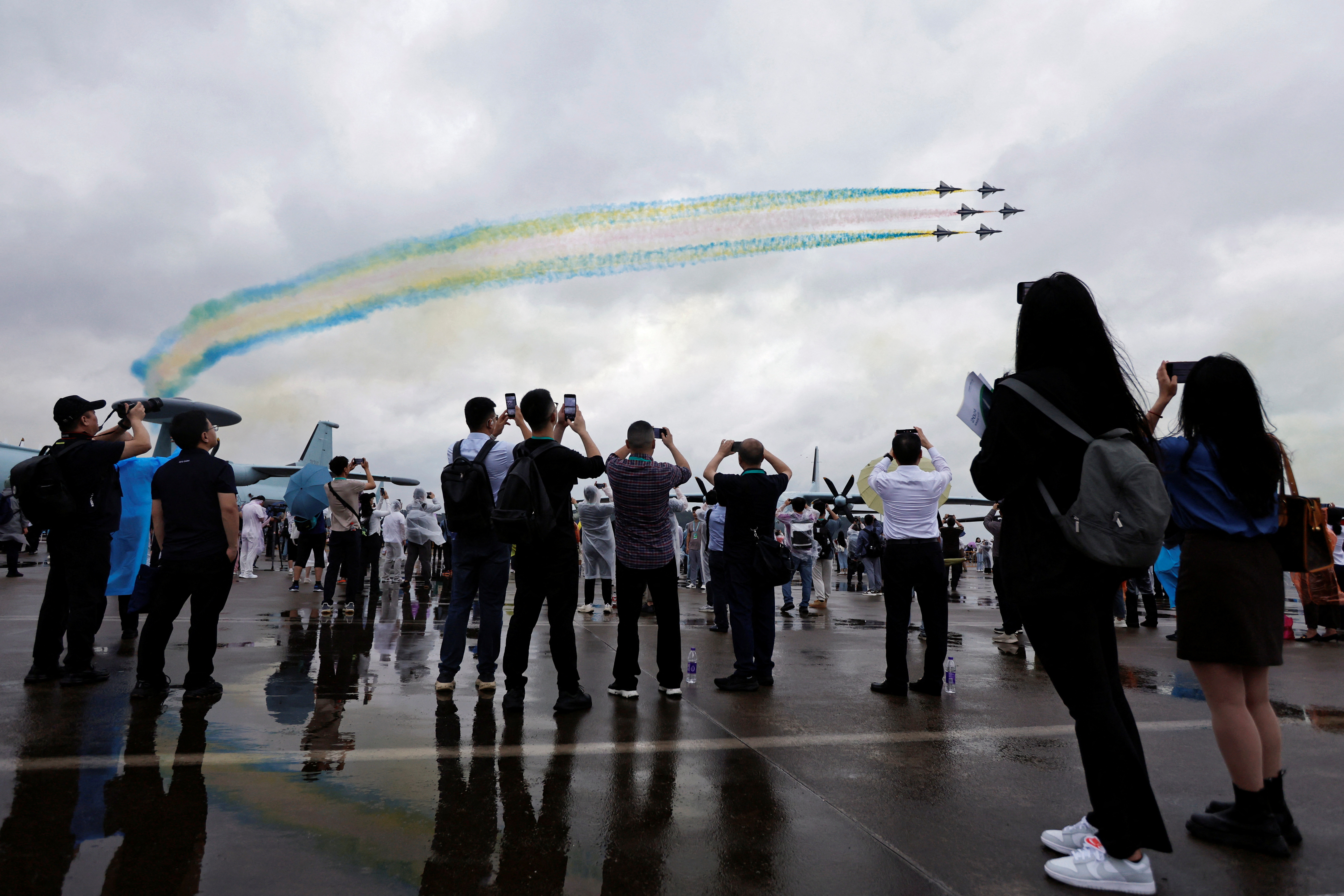 Visitors watch aircraft of the Chinese People's Liberation Army (PLA) Air Force's Bayi aerobatic team perform at the China International Aviation and Aerospace Exhibition, or Airshow China, in Zhuhai, Guangdong province, China November 14, 2024. REUTERS/Tingshu Wang