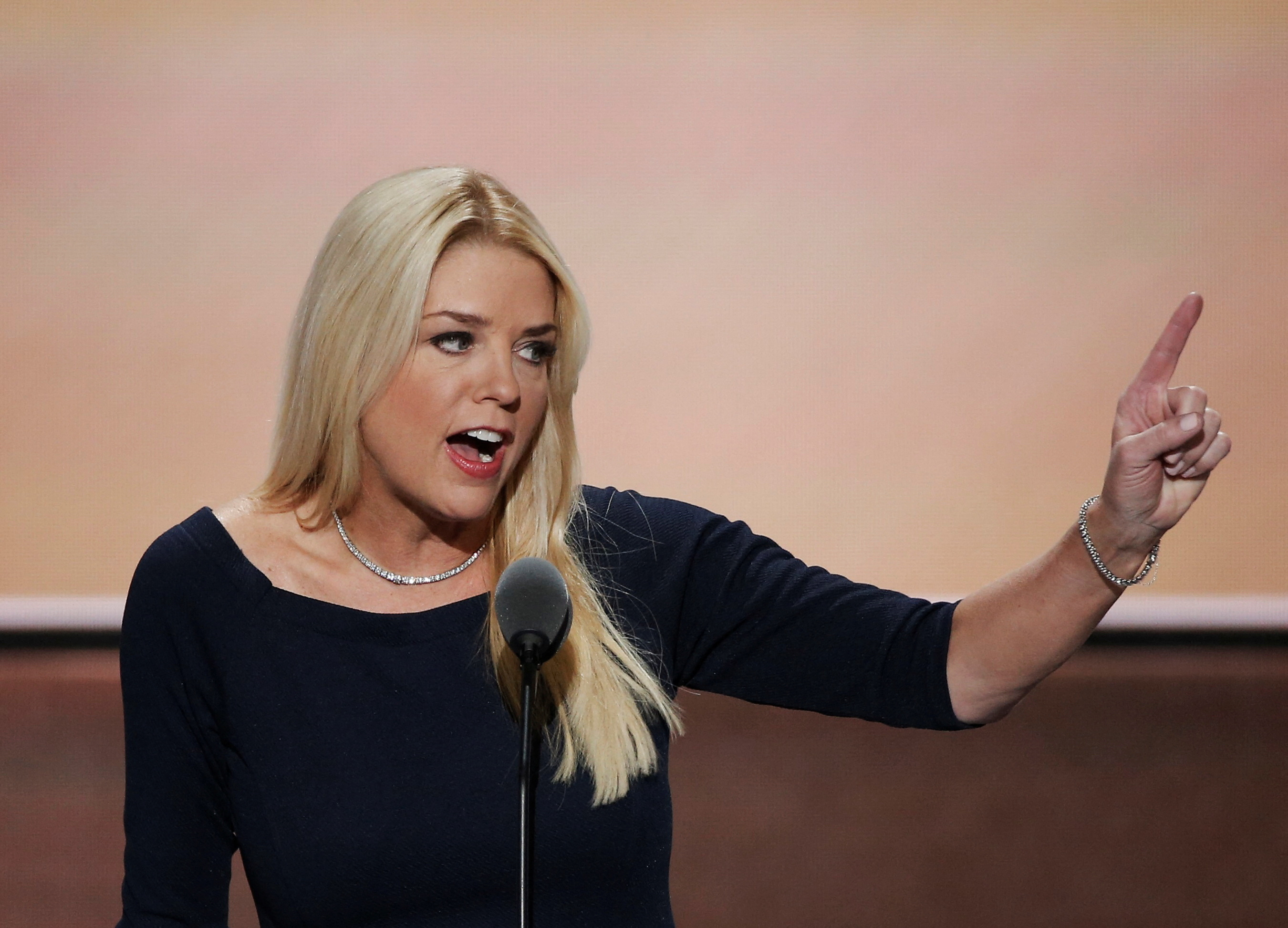 Pam Bondi points her finger while speaking at a microphone
