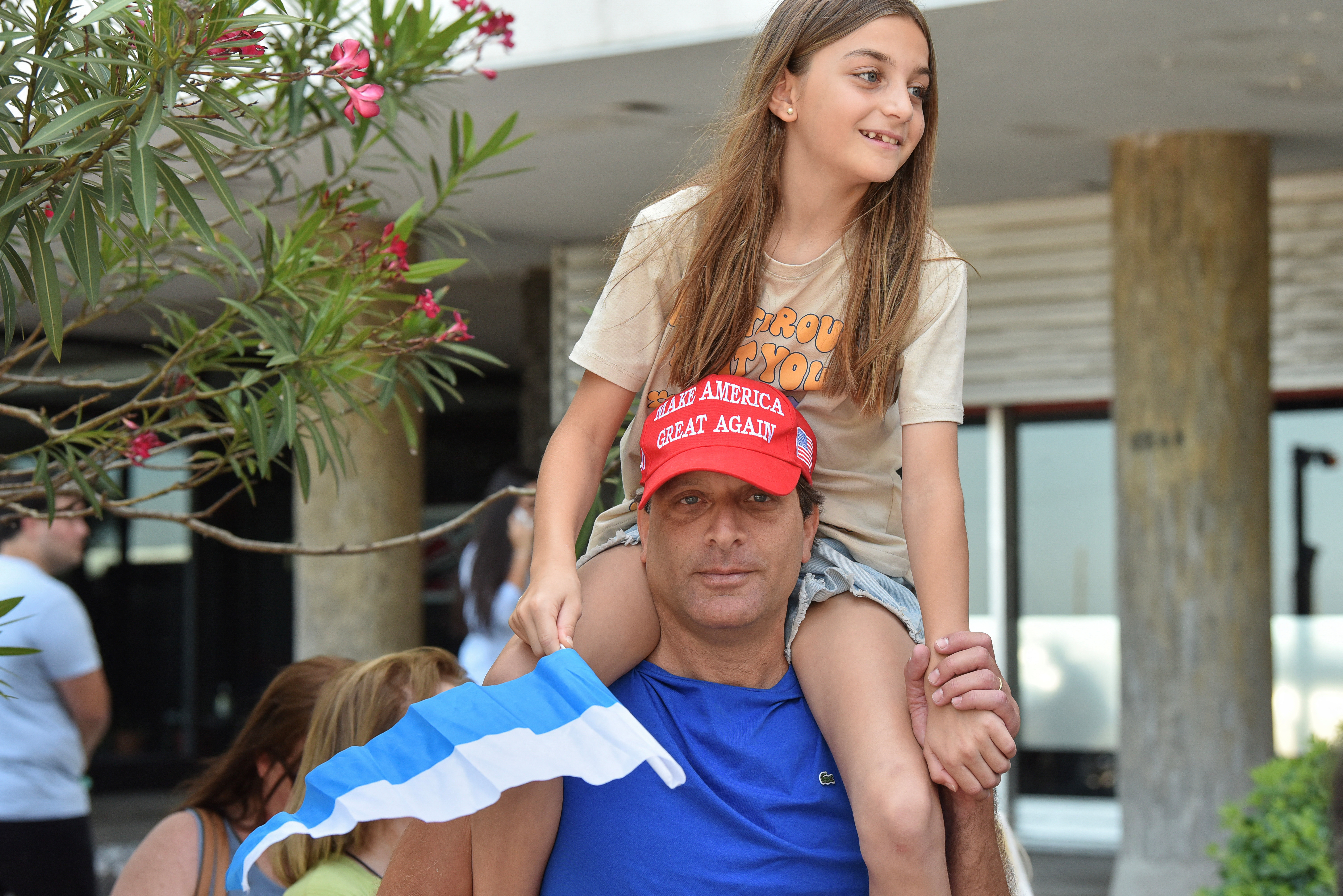 A Uruguay voter with his daughter on his shoulders wears a "Make America Great Again" hat.
