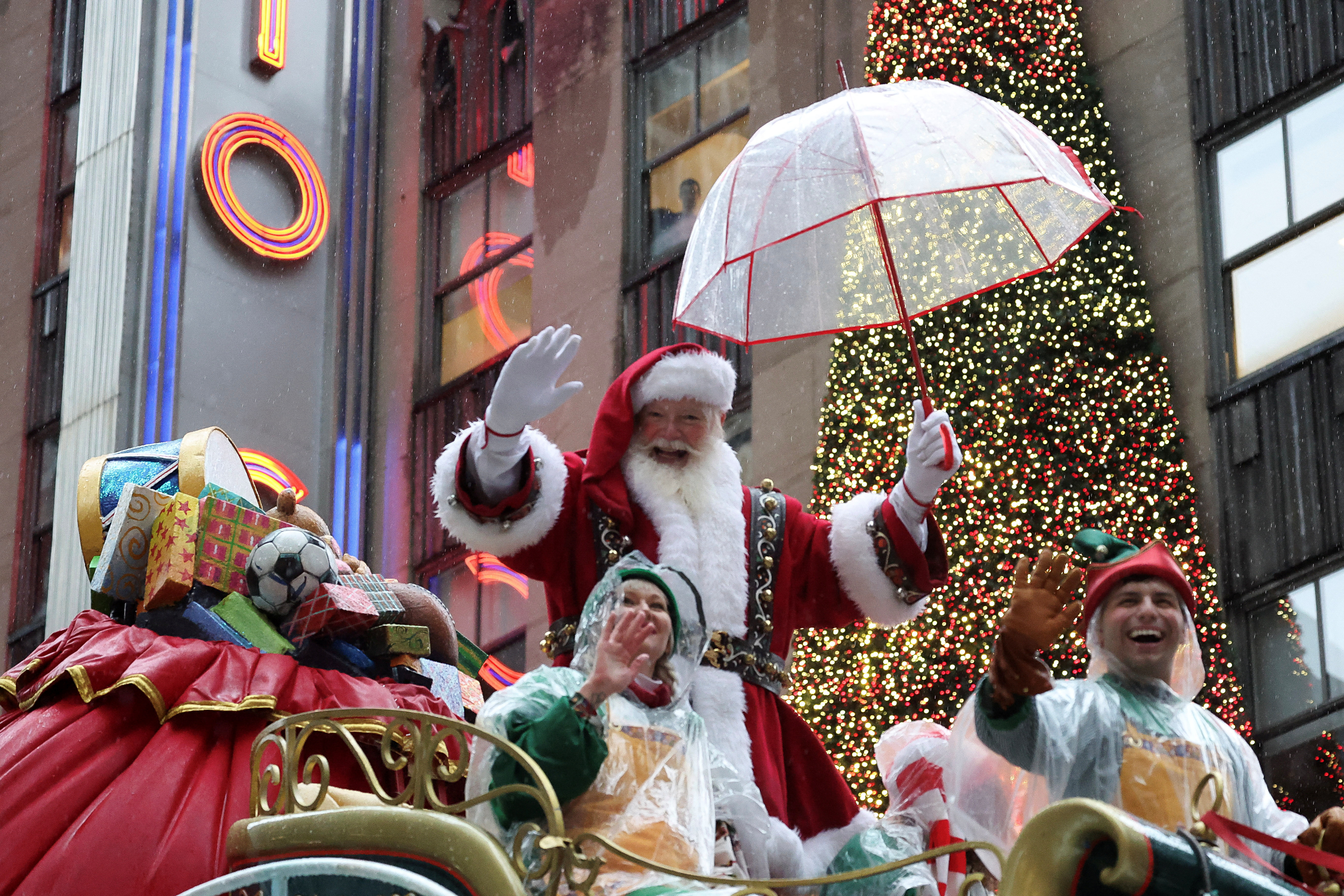 Santa Claus holds an umbrella atop a float in the Macy's Thanksgiving event.