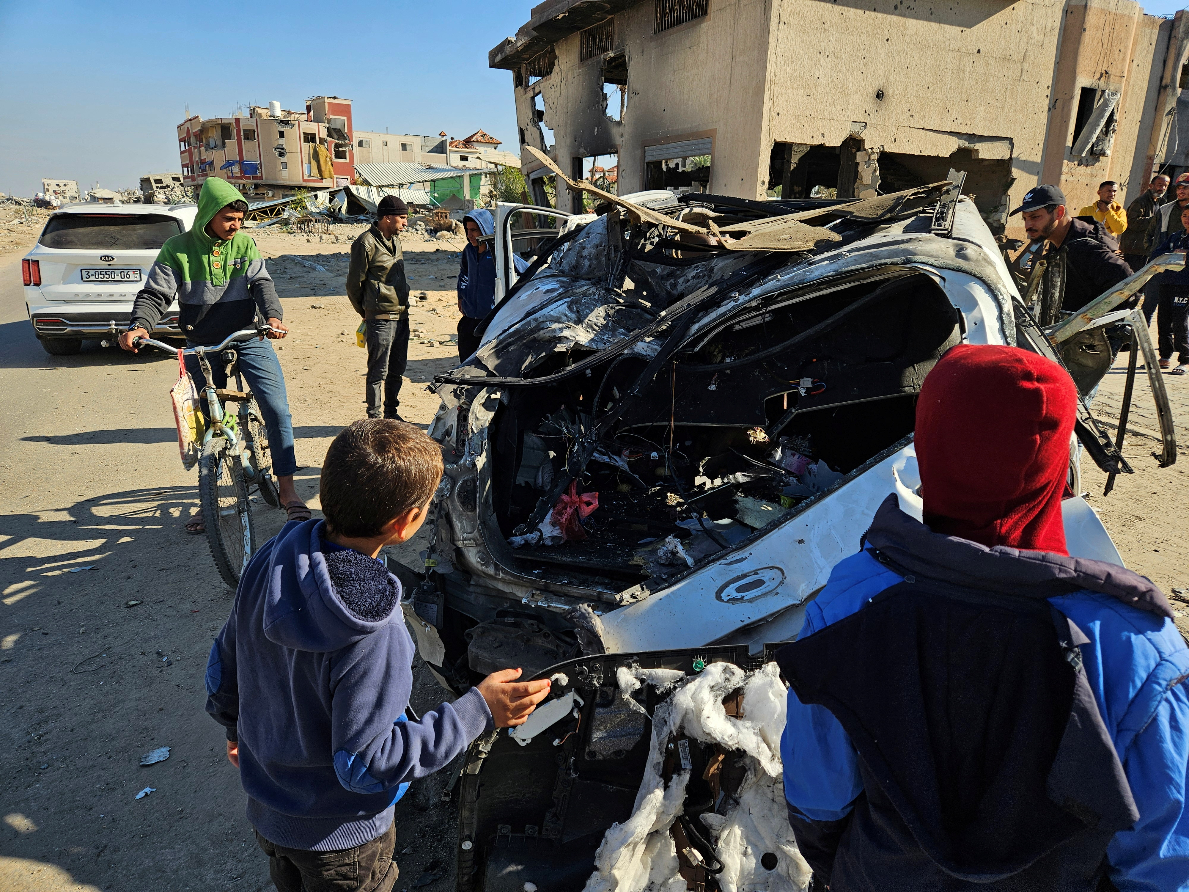 Palestinians inspect a vehicle in which WCK employees were killed in an Israeli attack in Khan Younis, southern Gaza