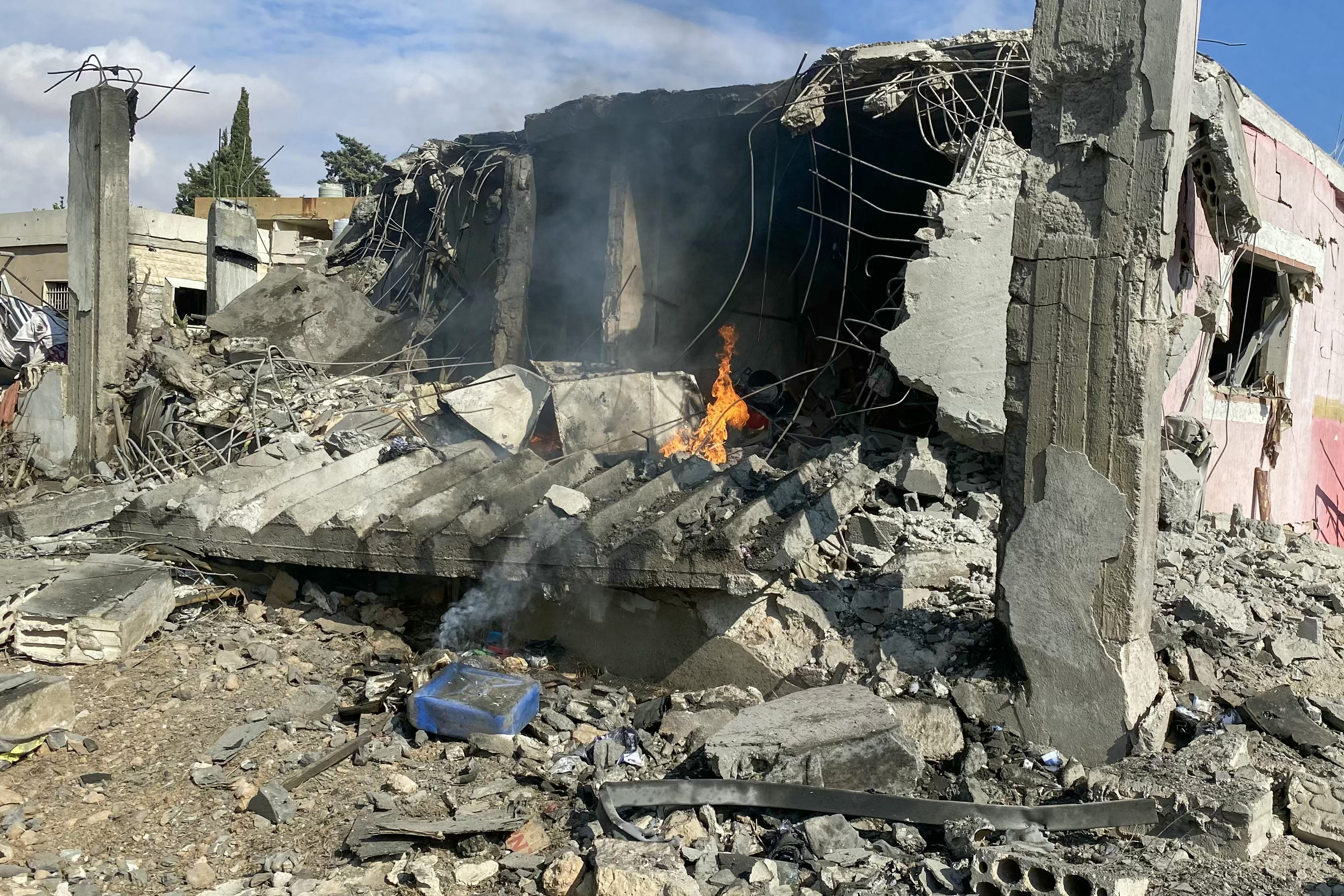 A fire burns at a destroyed house following an Israeli airstrike that targeted Lebanon's eastern town of Hermel