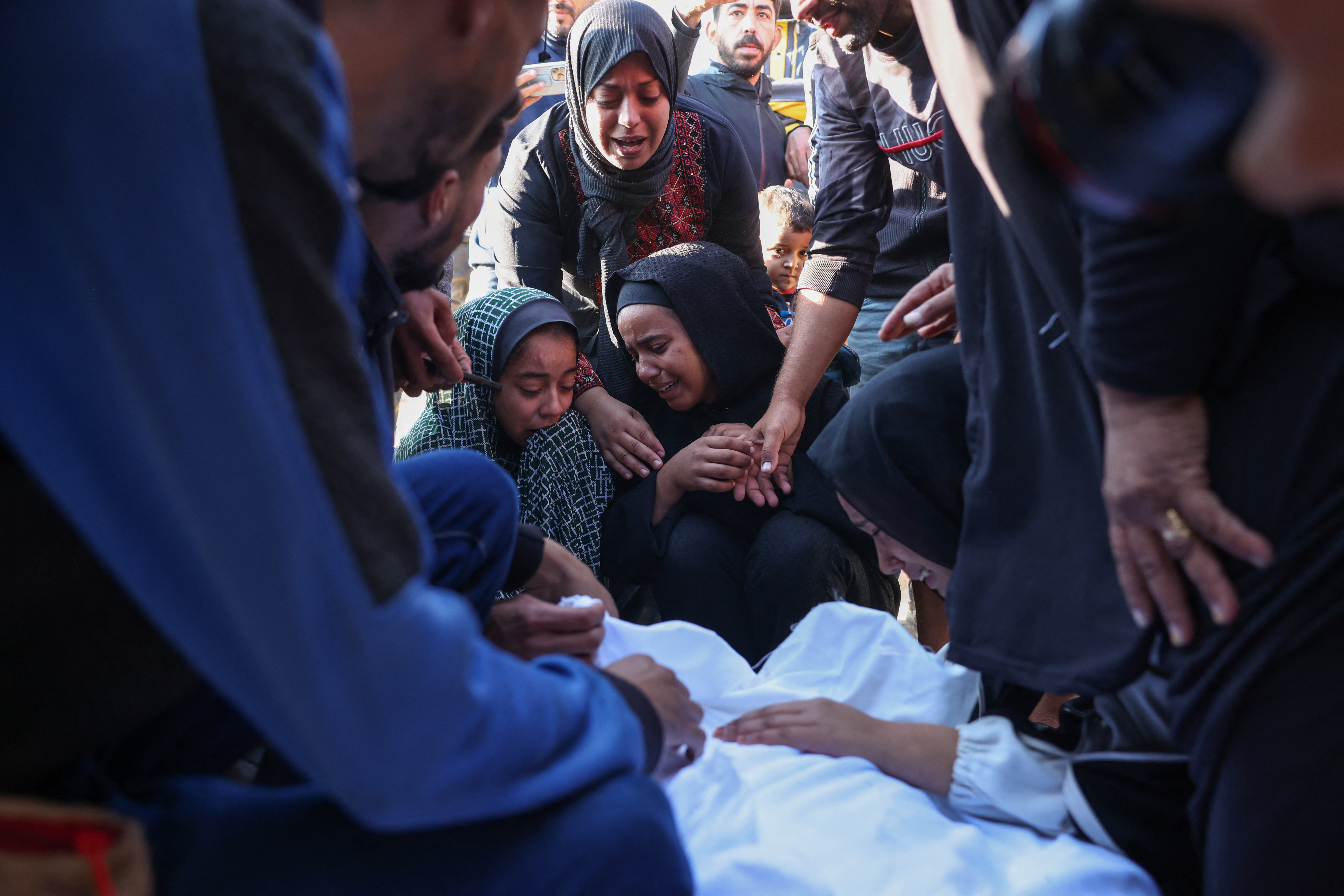 Palestinians mourn by the body of a relative killed in overnight Israeli strikes on the al-Mawasi cafeteria in southern Gaza's Khan Yunis, at Nasser hospital on November 12, 2024, amid the ongoing war between Israel and the Palestinian Hamas movement. (Photo by BASHAR TALEB / AFP)