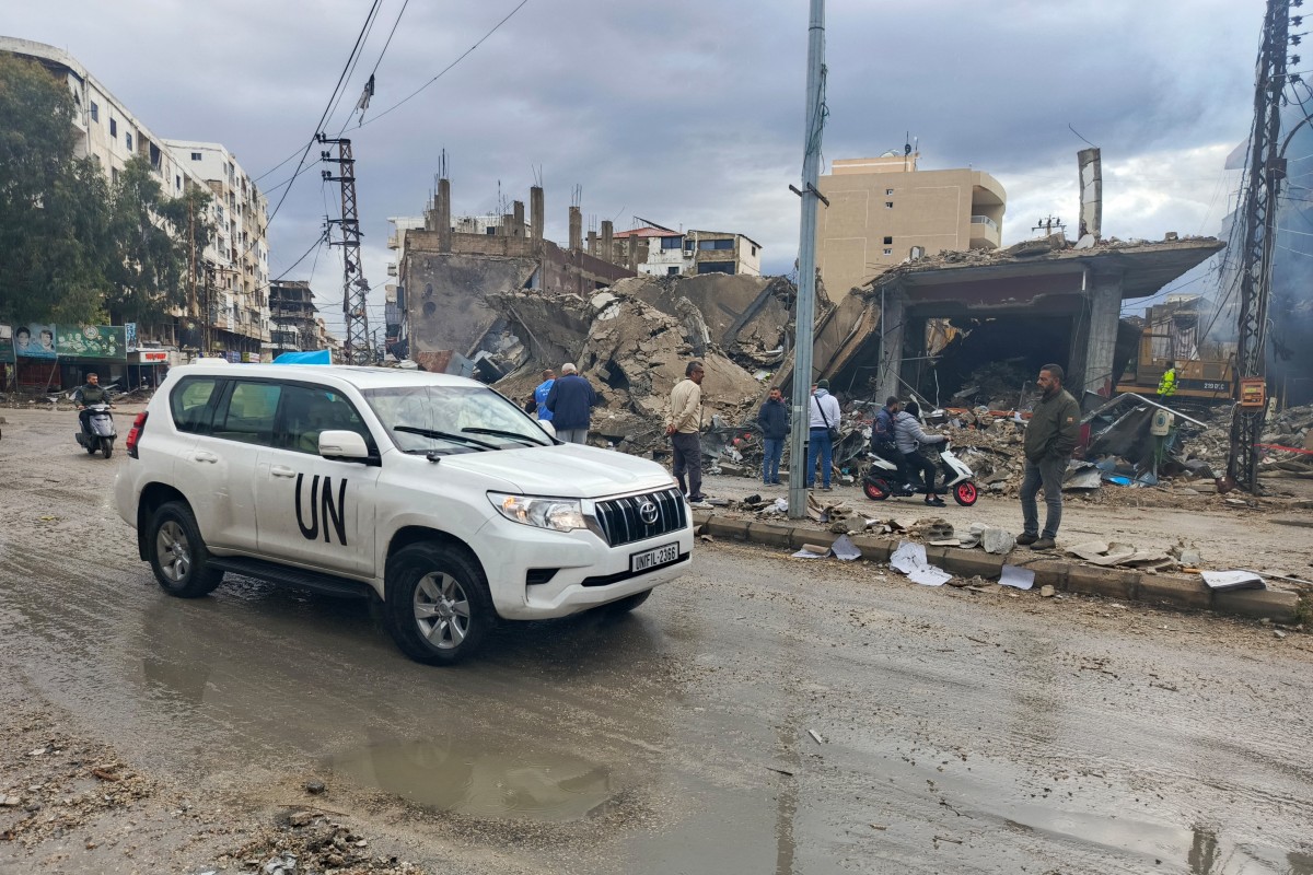 A UN vehicle drives past destruction following an overnight airstrike that targeted the eastern entrance of the southern Lebanese city of Tyre on November 19, 2024, amid the ongoing war between Israel and Hezbollah. (Photo by KAWNAT HAJU / AFP)