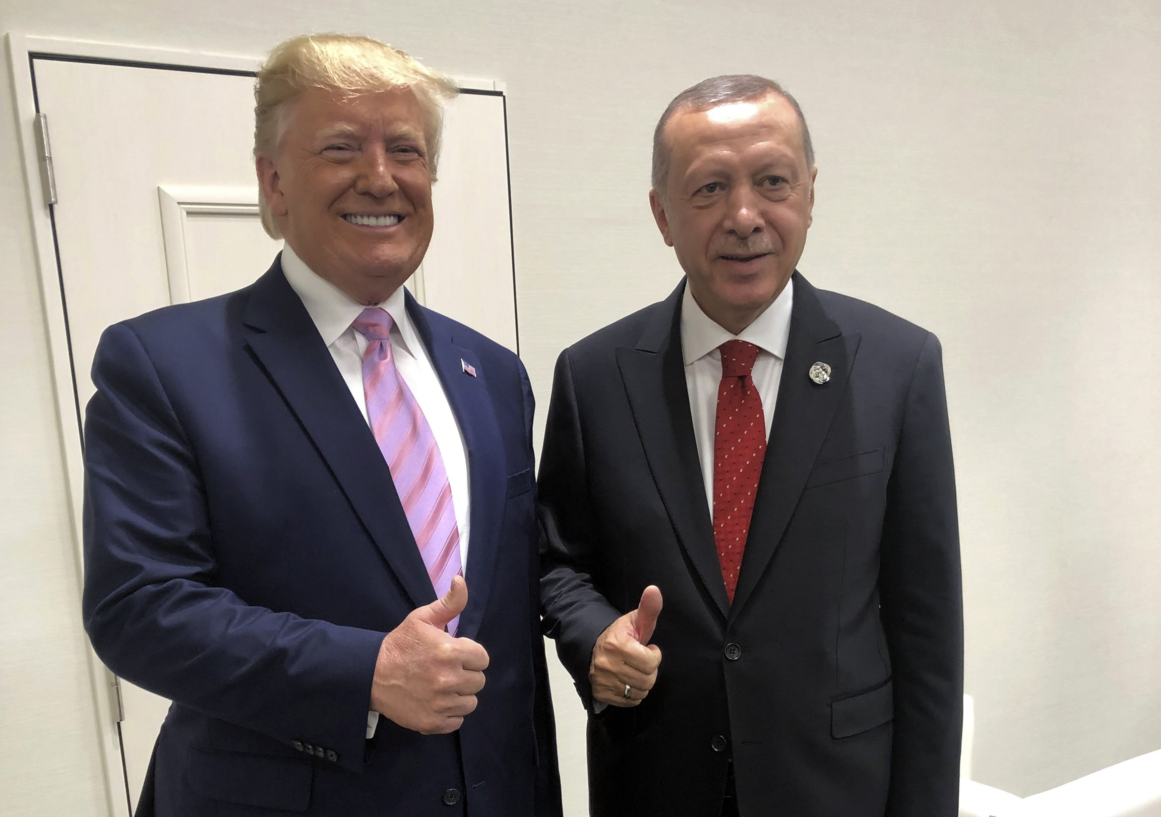 Turkey's President Recep Tayyip Erdogan, right, and US President Donald Trump gesture during the G-20 summit in Osaka, Japan, Friday, June 28, 2019. [File: Presidential Press Service/AP]