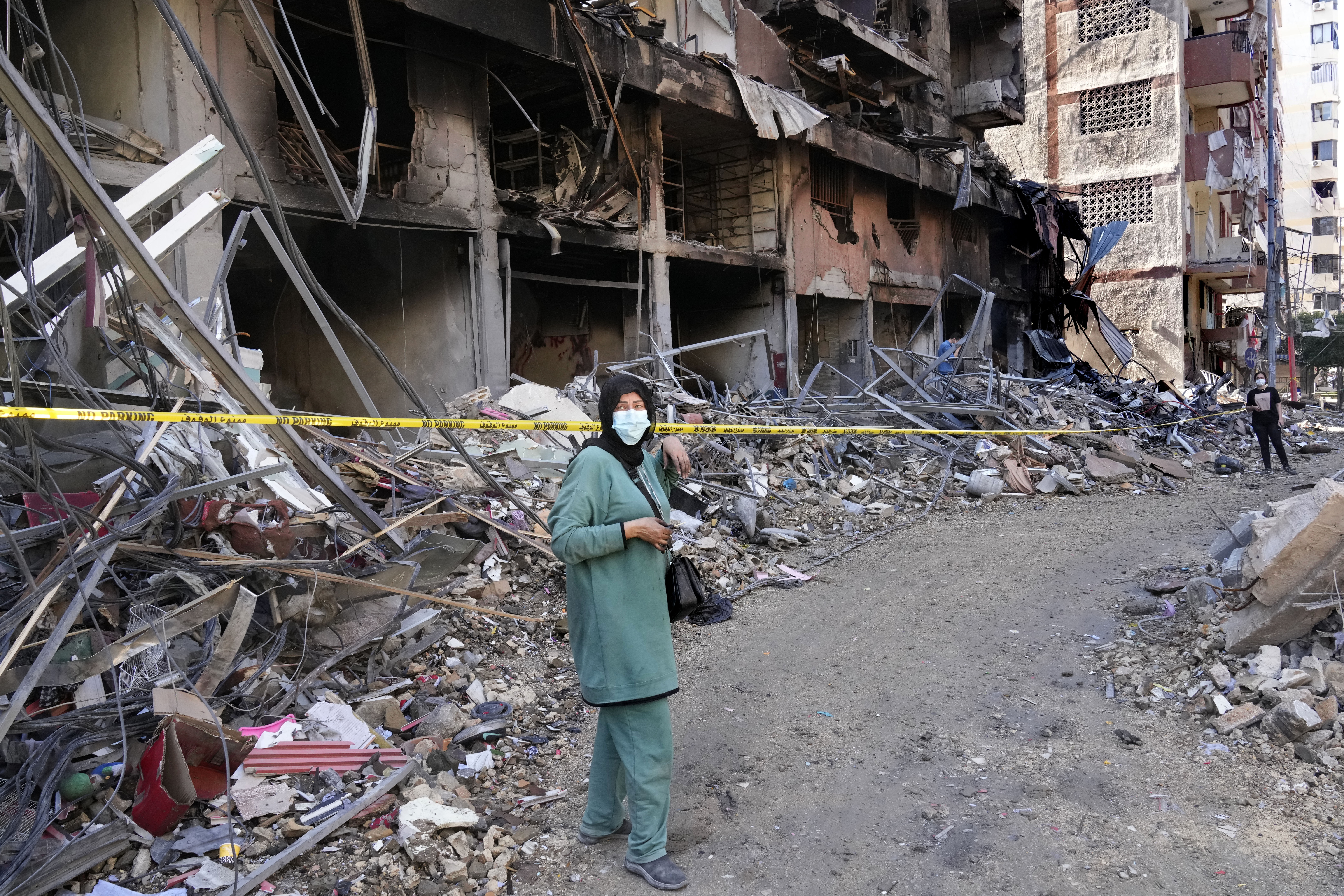 A woman stands in front of a building that was destroyed by an Israeli airstrike in Dahiyeh, in the southern suburb of Beirut, Lebanon