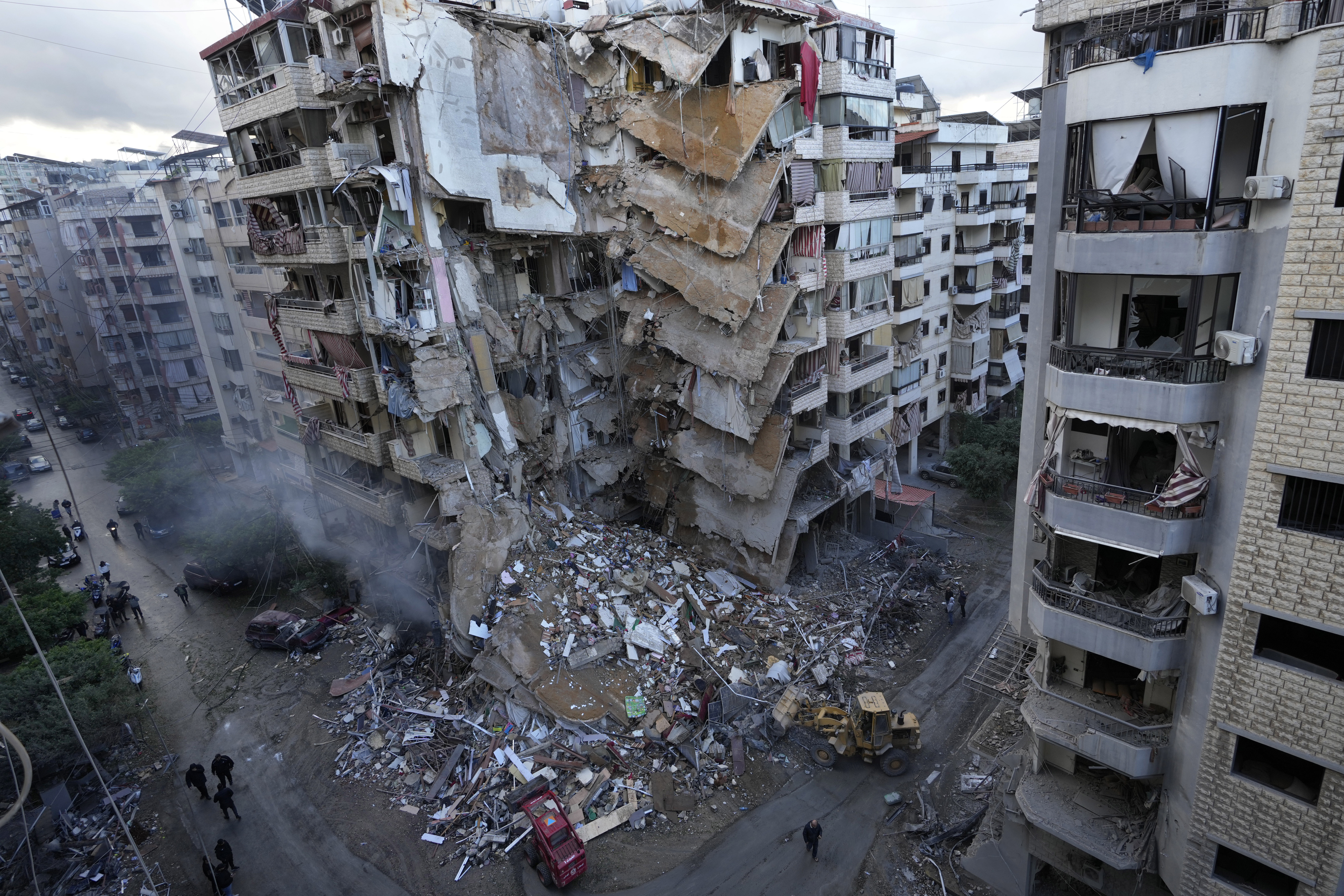 Bulldozers remove the rubble of a destroyed building that was hit Sunday night in an Israeli airstrike in Dahiyeh