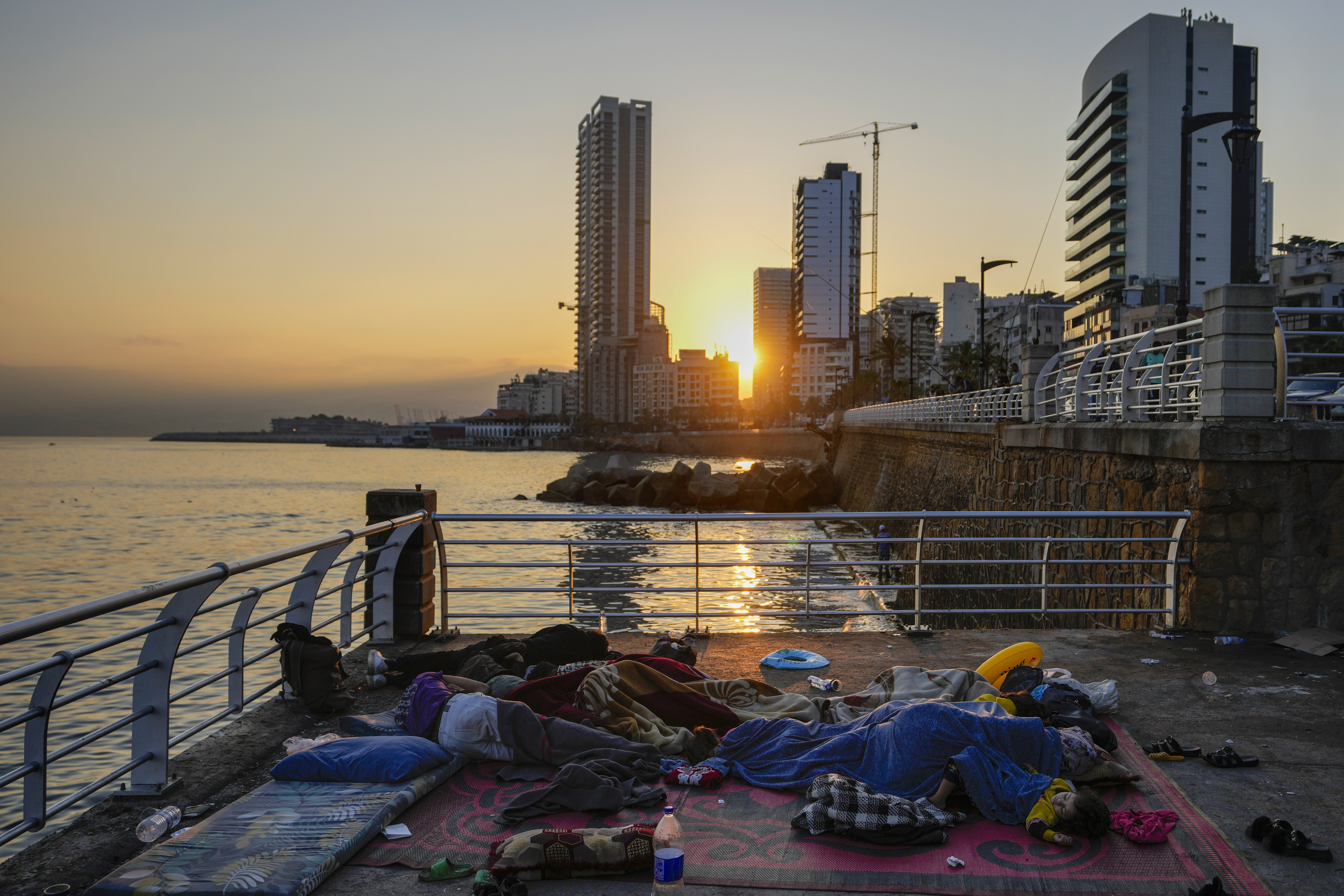 Families sleep on Beirut's corniche after fleeing the Israeli airstrikes in Beirut's southern suburb