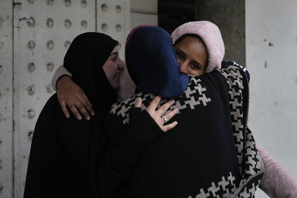 People hug each other upon their arrival at their neighborhood as they celebrate a ceasefire between Hezbollah and Israel, which began early morning, in Tyre, south Lebanon, Wednesday, Nov. 27, 2024. (AP Photo/Hussein Malla)