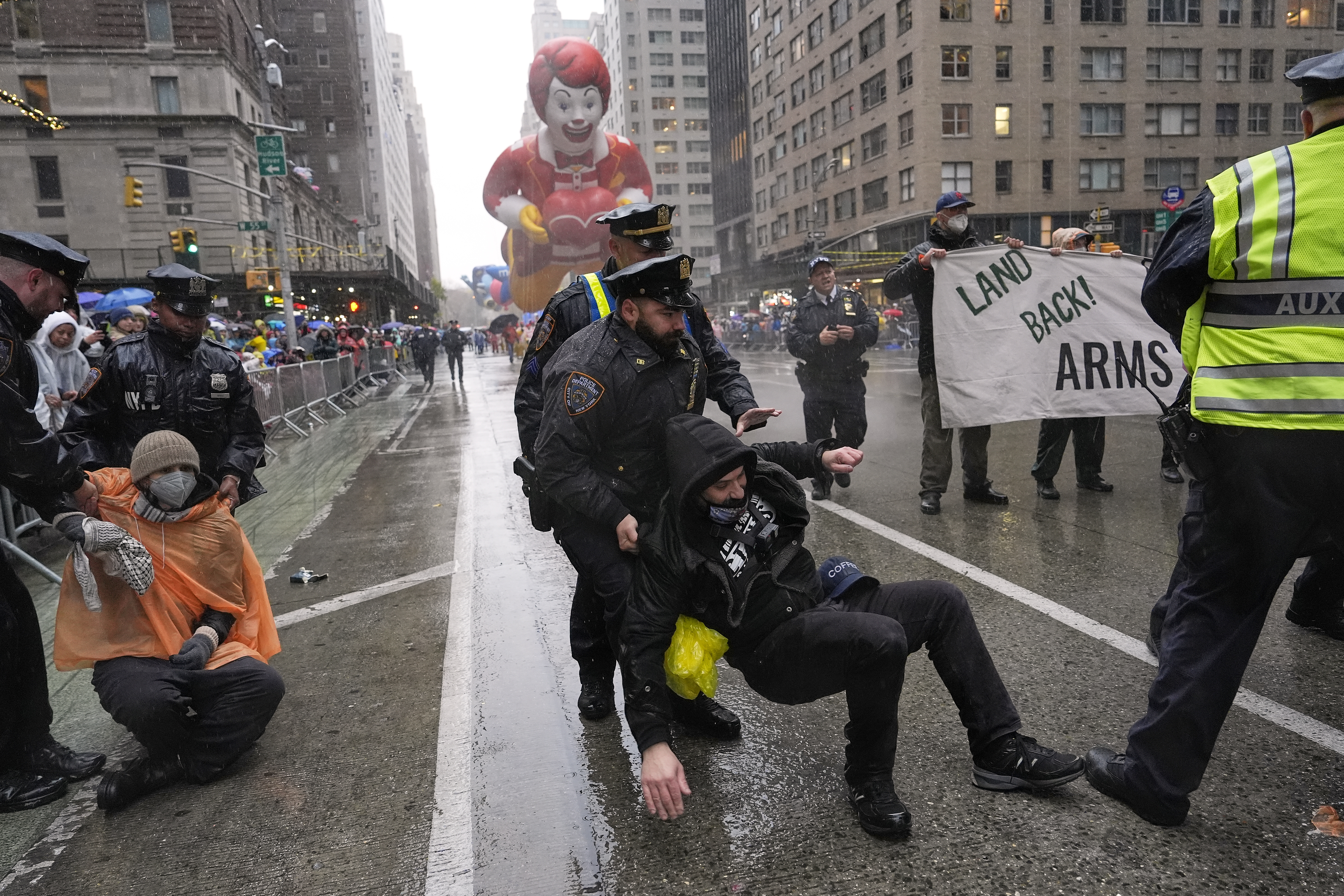 A police officer pulls a protester down on a rainy New York street