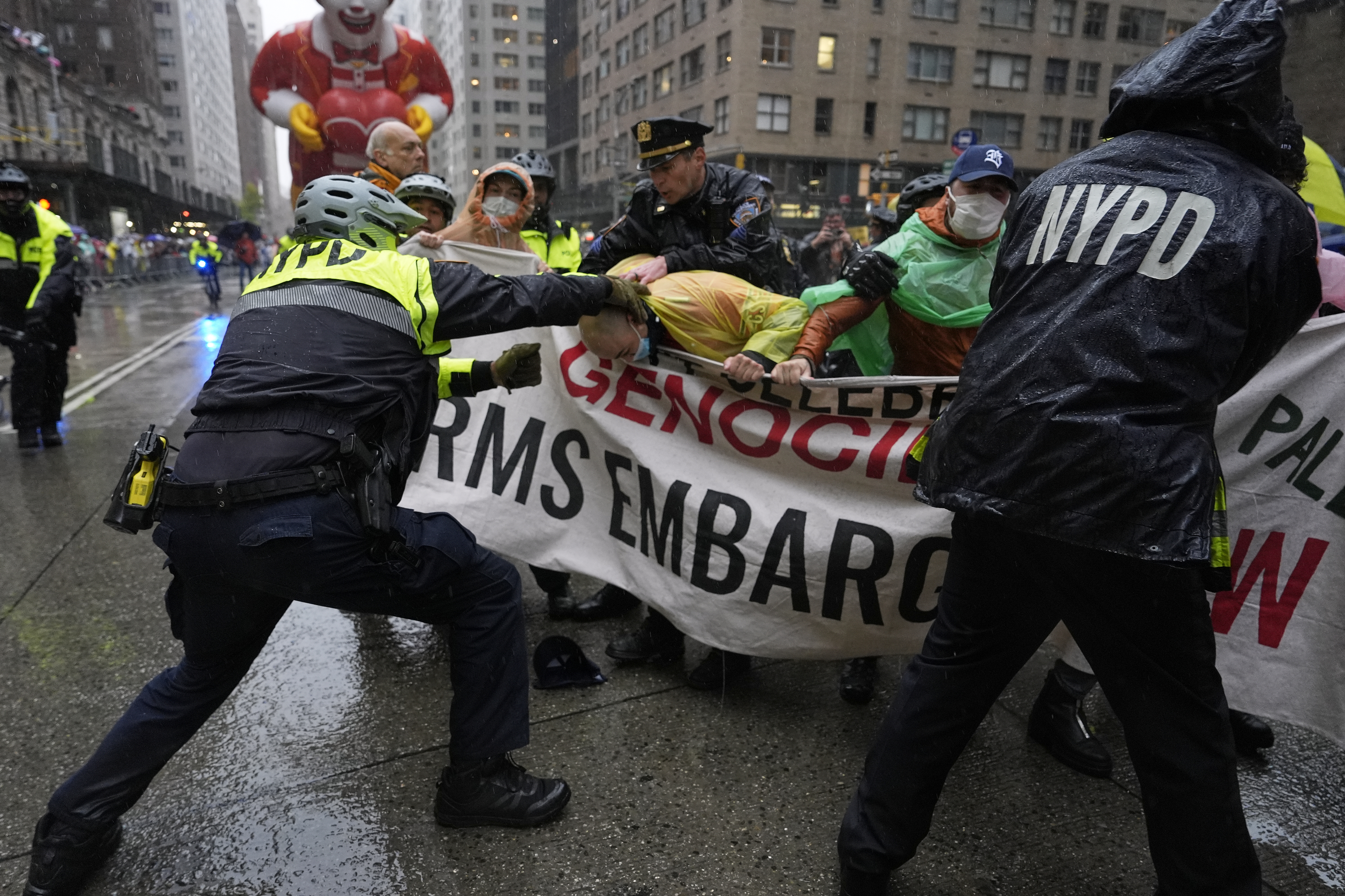 Pro-Palestinian protesters holding up a banner denouncing genocide are detained by police