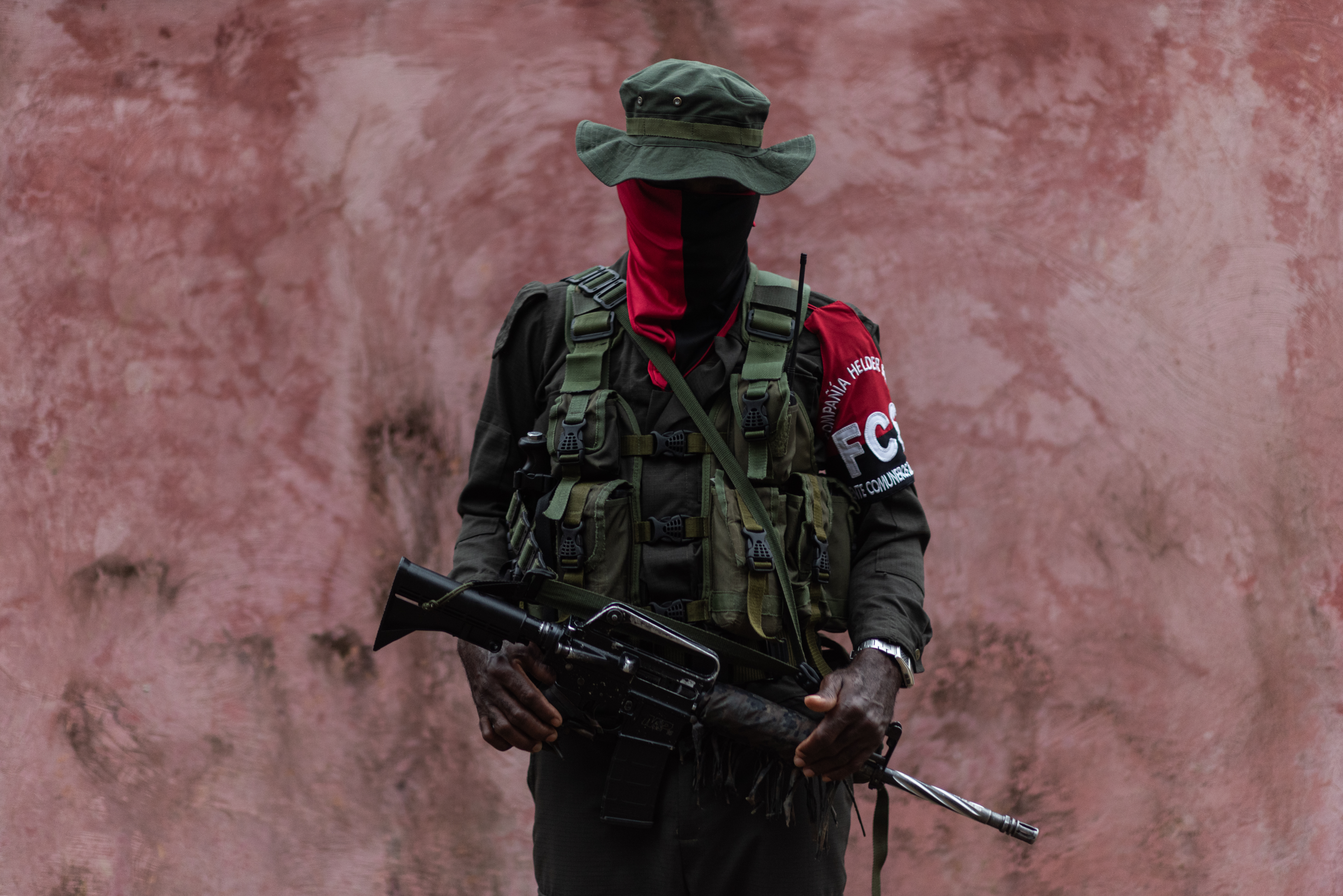 A Comuneros del Sur fighter, wearing fatigues with a red scarf around his face.