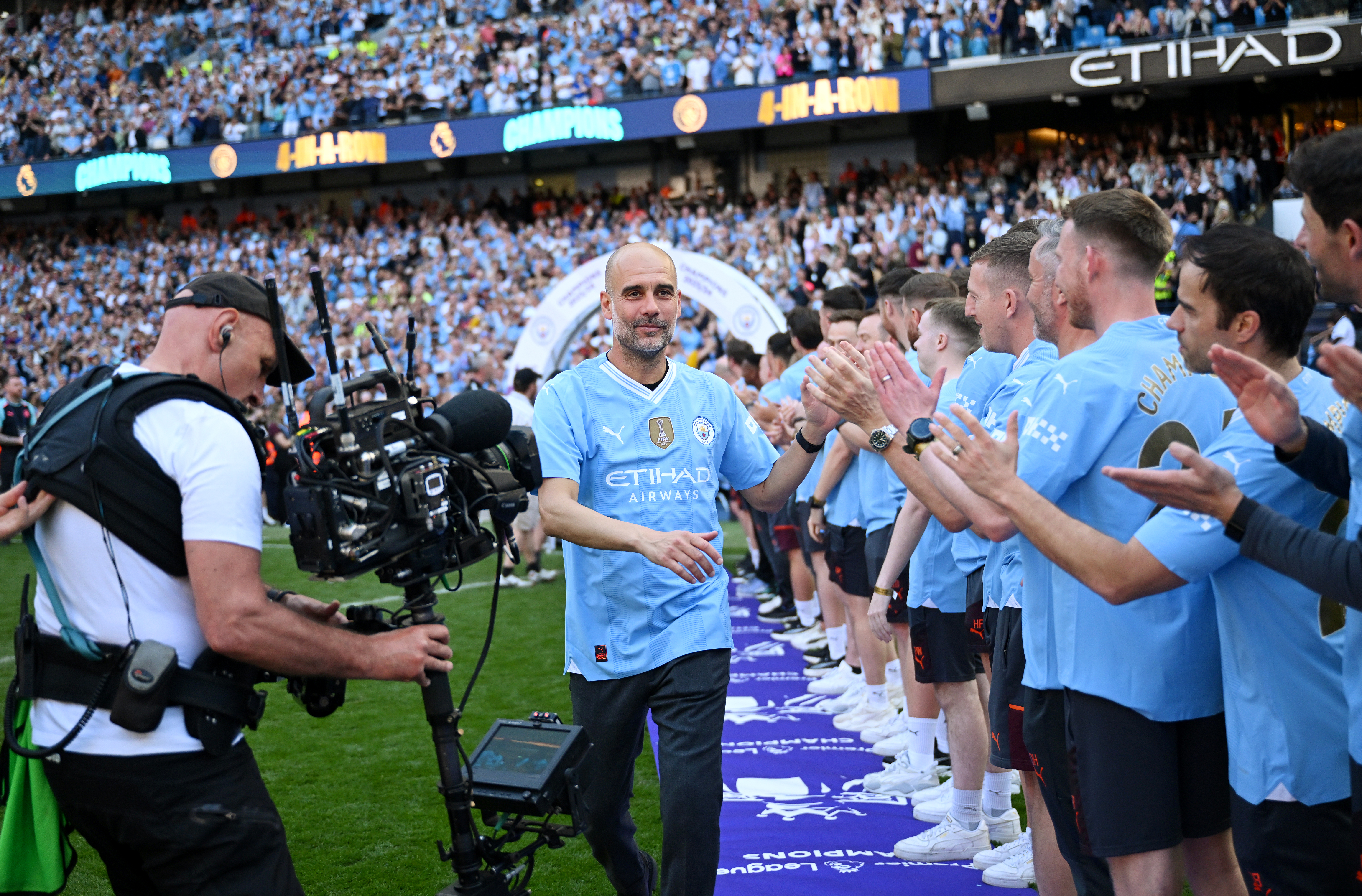 MANCHESTER, ENGLAND - MAY 19: Pep Guardiola, Manager of Manchester City, congratulates staff after the team's victory as Premier League champions before the trophy ceremony during the Premier League match between Manchester City and West Ham United at Etihad Stadium on May 19, 2024 in Manchester, England. (Photo by Michael Regan/Getty Images)
