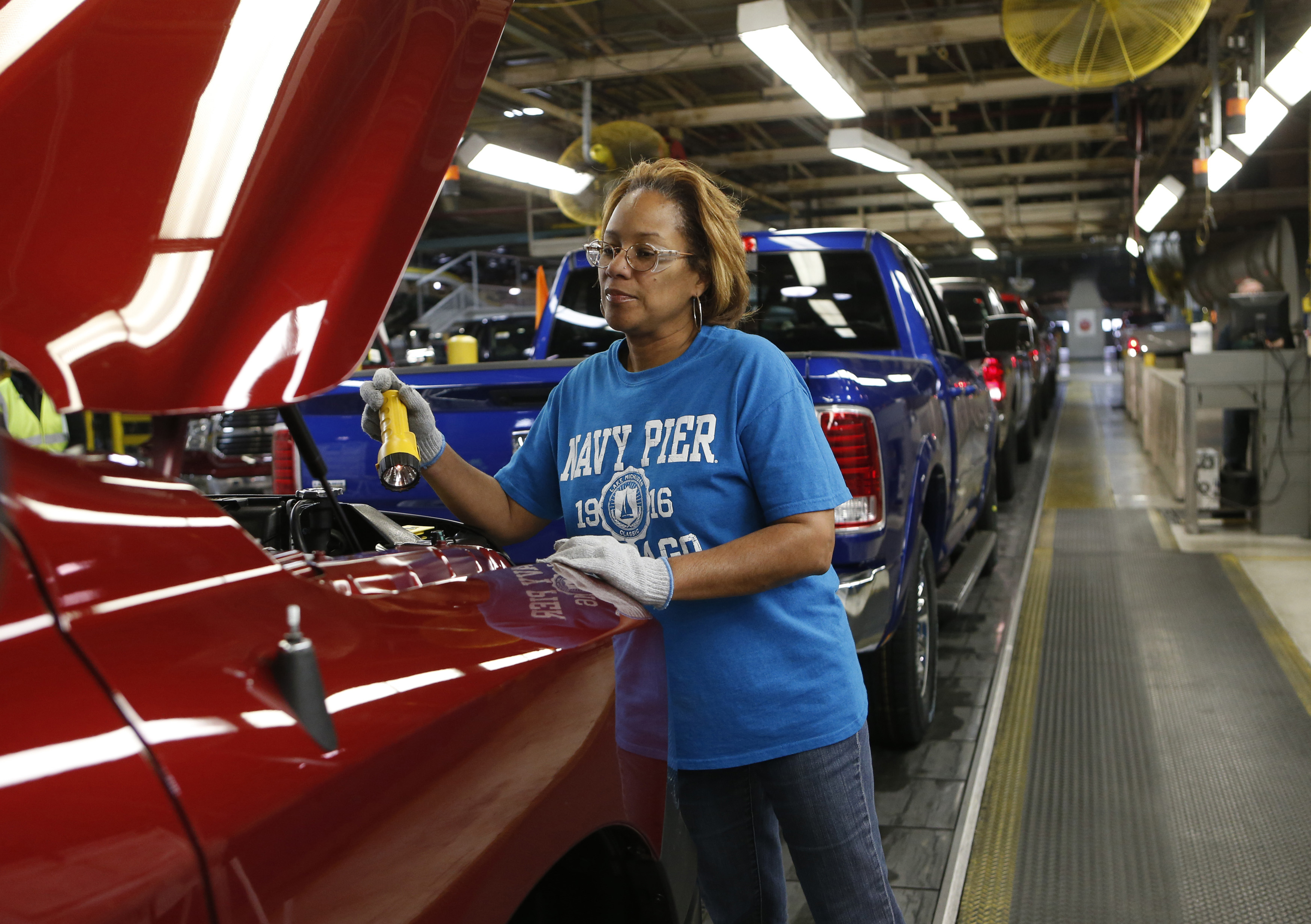 A Chrysler assembly worker checks a vehicle on an assembly line in Michigan, US
