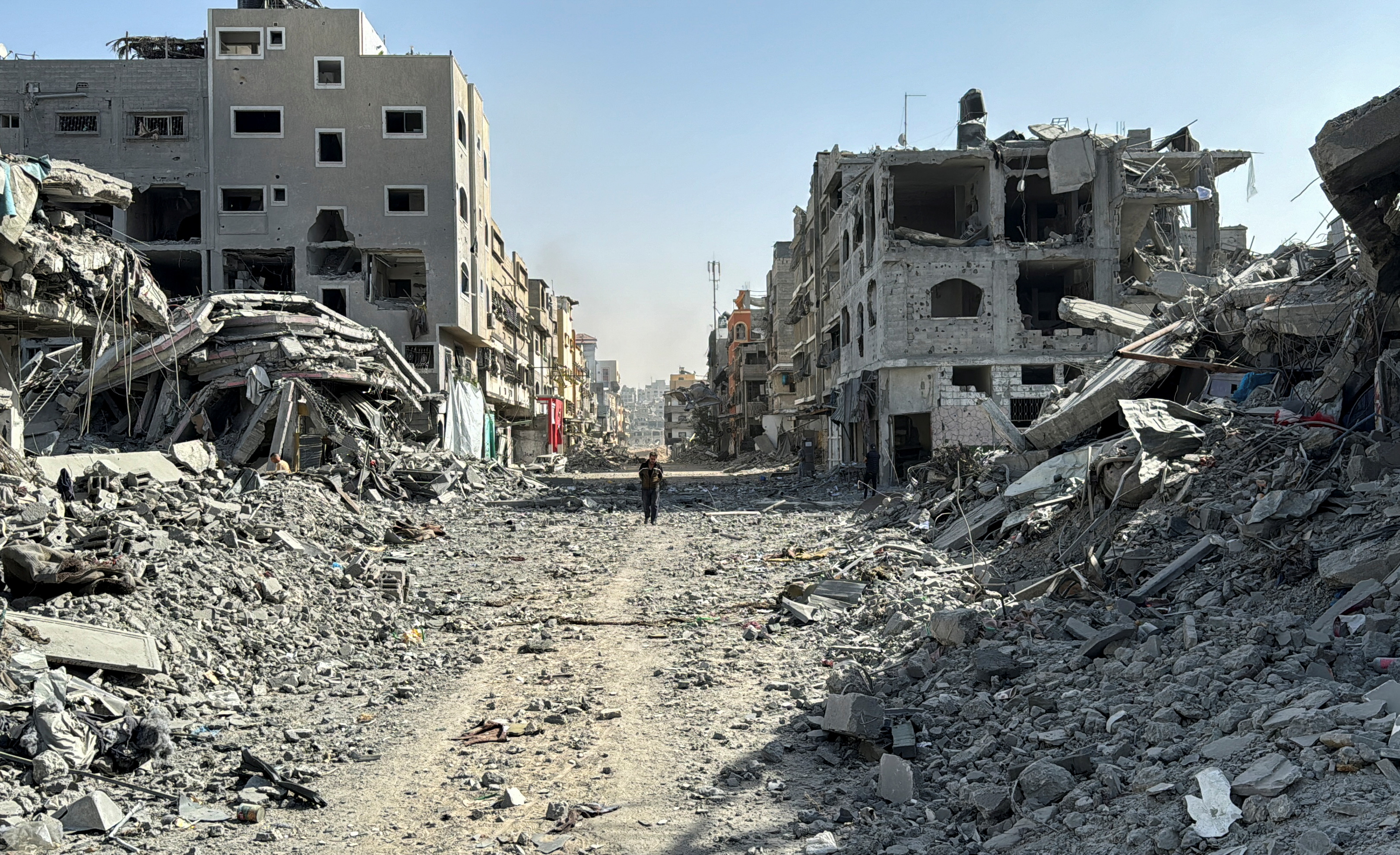 A Palestinian man walks past the rubble after Israeli forces withdrew from the area around Kamal Adwan hospital