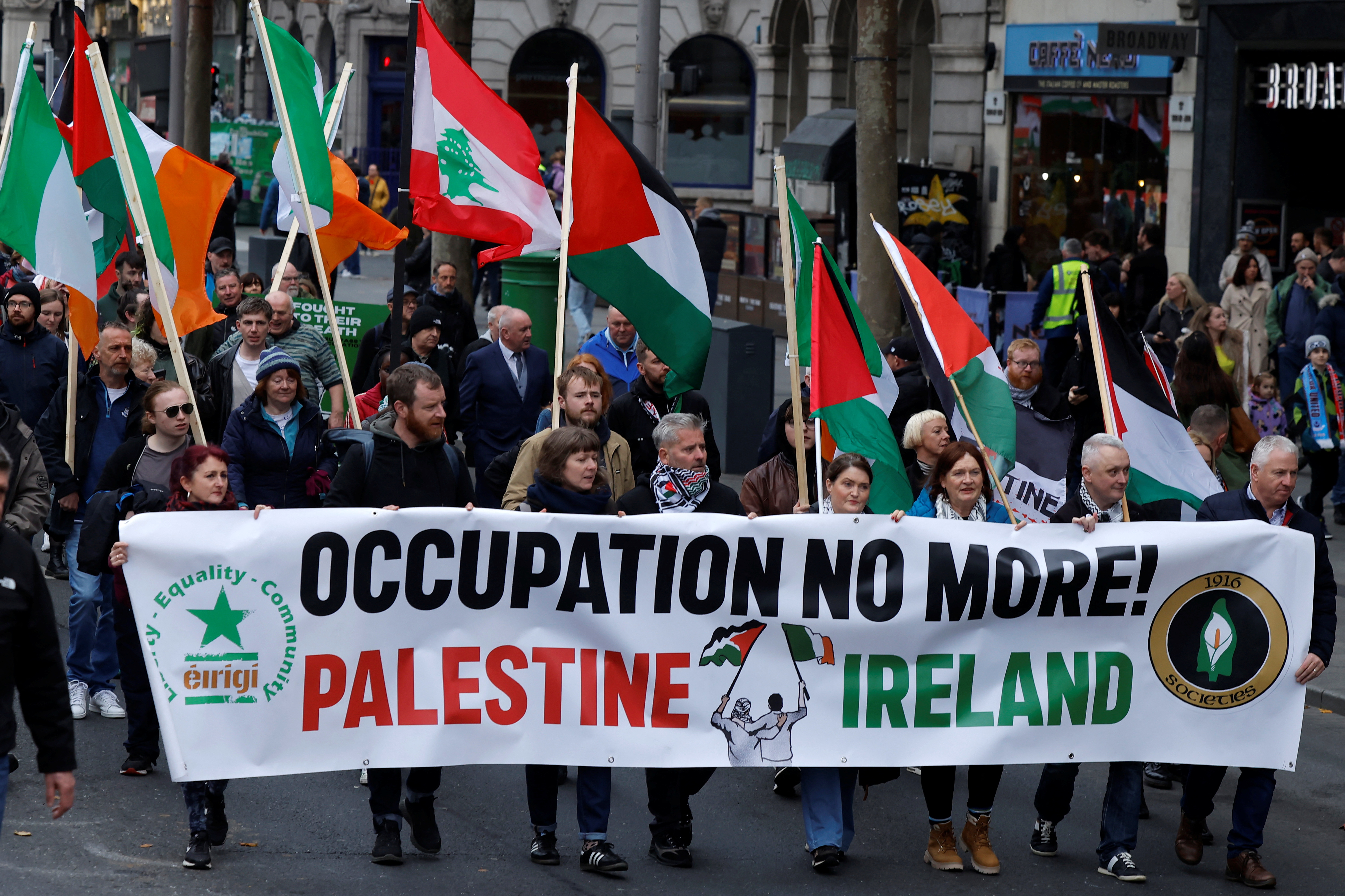 Protesters carry flags of Ireland, Palestine and Lebanon and hold a banner saying 'Occupation no more! Palestine Ireland'