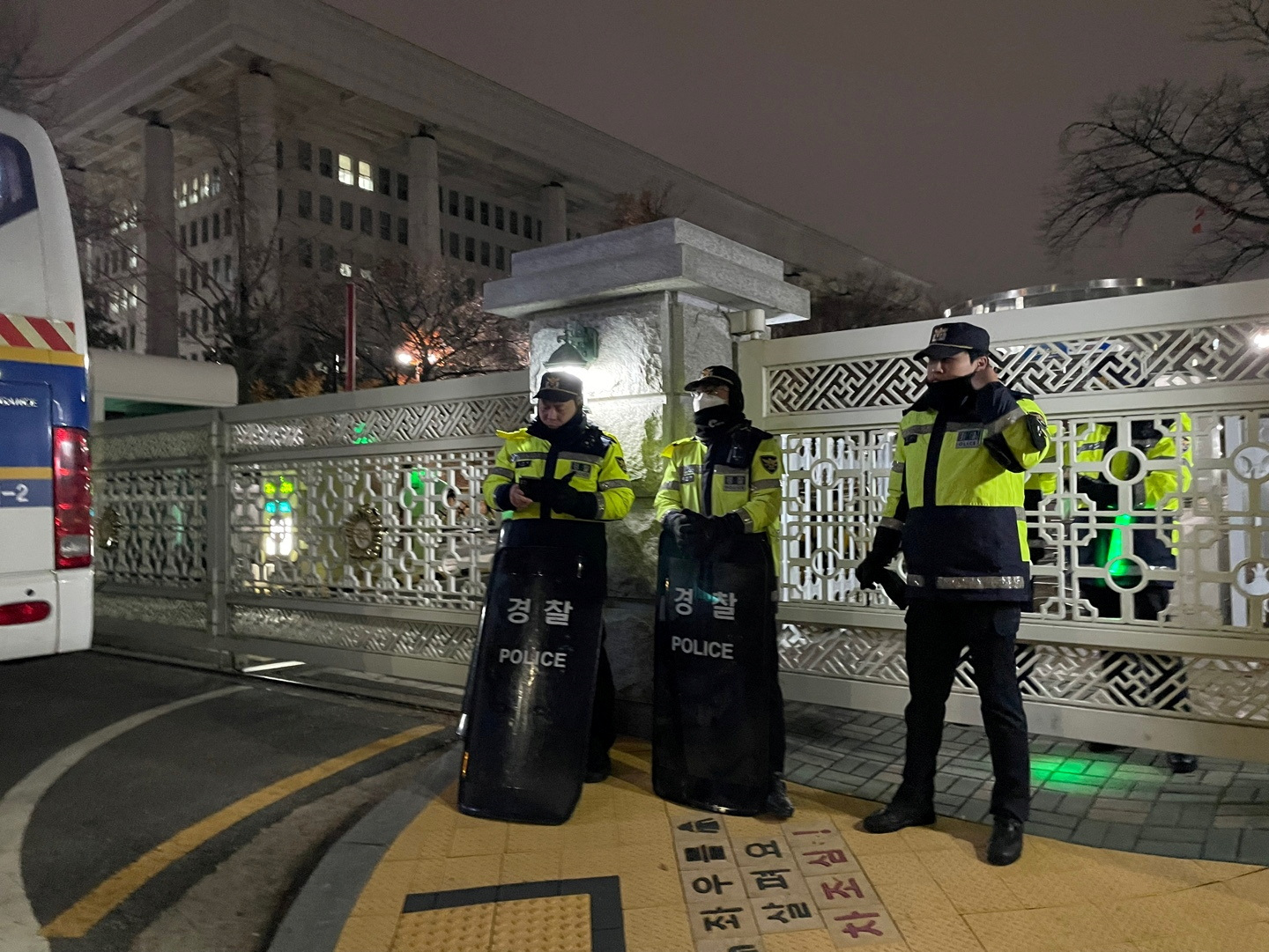 Policemen stand in front of the gate to the National Assembly