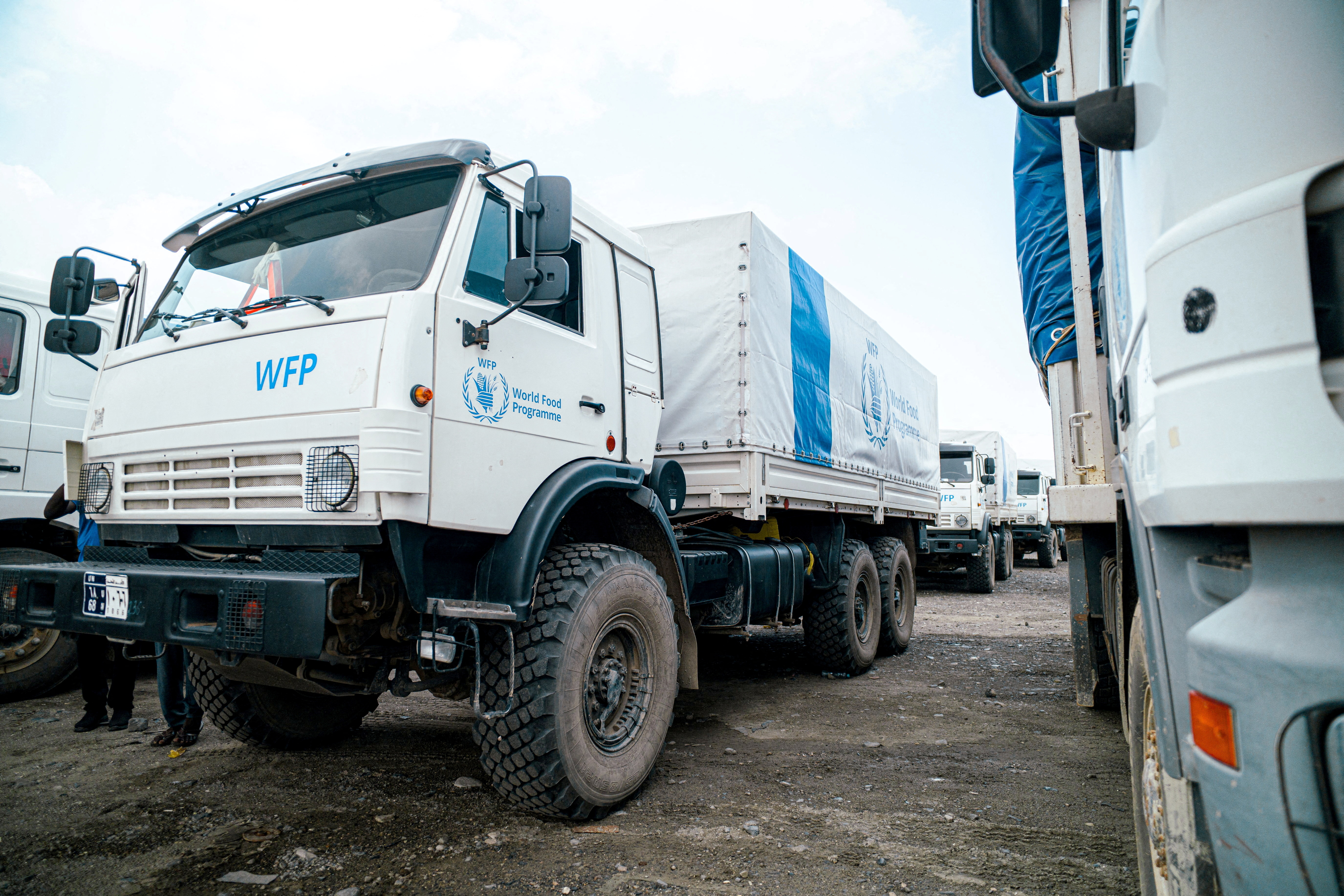 WFP workers stand next to trucks carrying aid