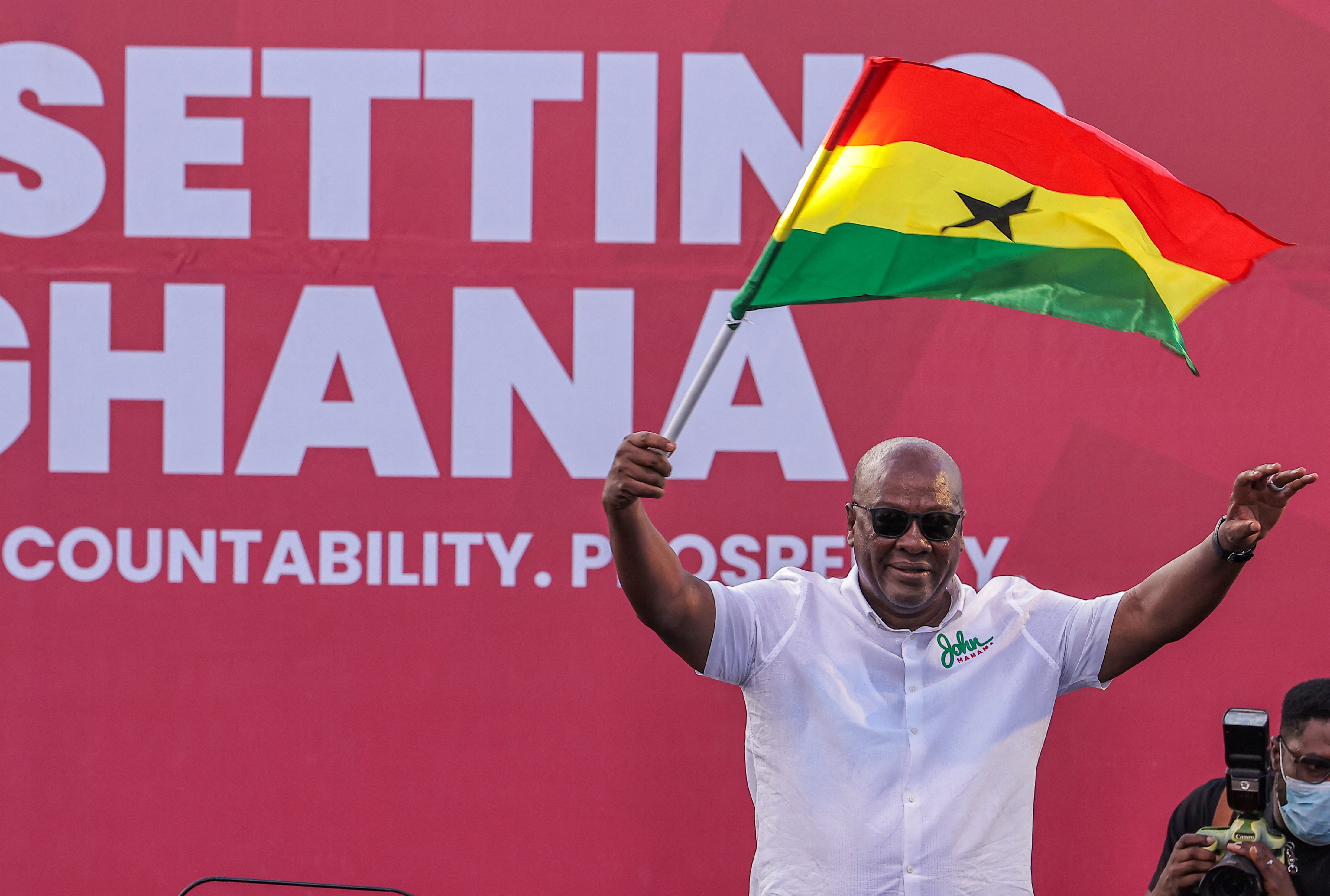 John Mahama holds a Ghanaian flag as he waves to supporters during his final election campaign rally in Accra on December 5 [Zohra Bensemra/Reuters]