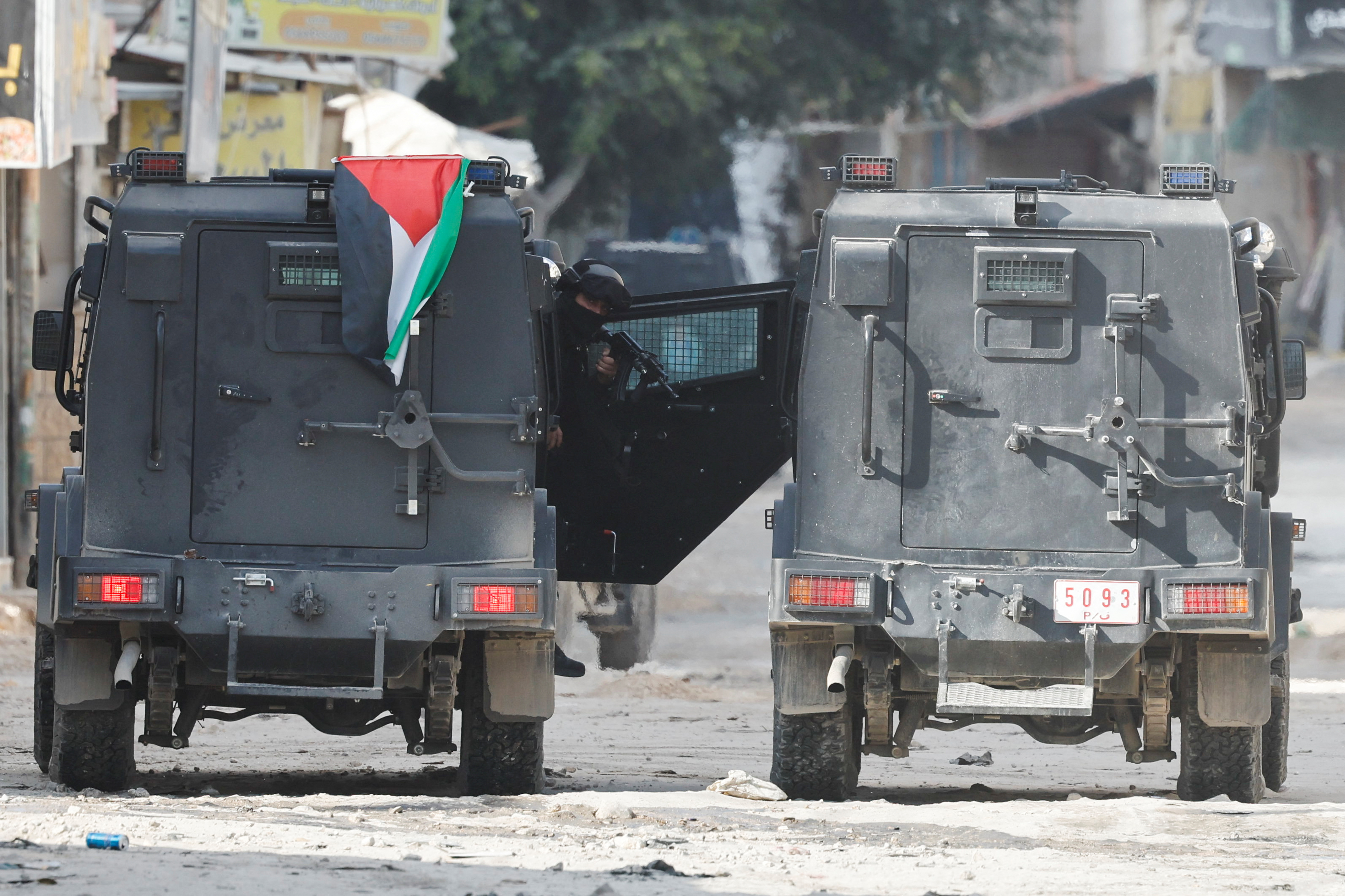A member of the Palestinian security forces looks out from a vehicle as they patrol amid clashes with militants at the camp, in Jenin in the Israeli-occupied West Bank, December 14, 2024. REUTERS/Raneen Sawafta