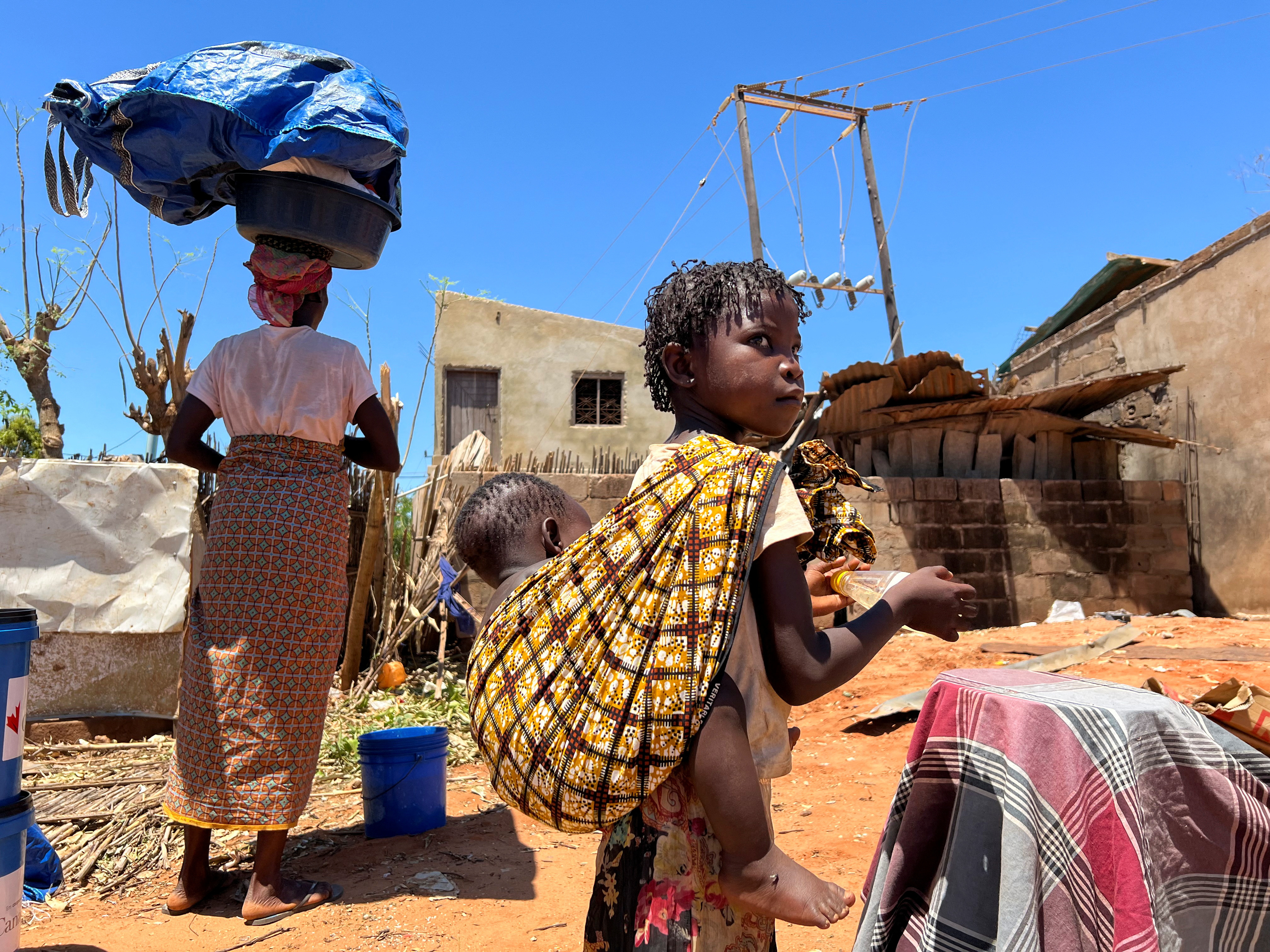 A woman and her children return to their damaged house after cyclone Chido in Pemba, Mozambique, December 18, 2024. 
