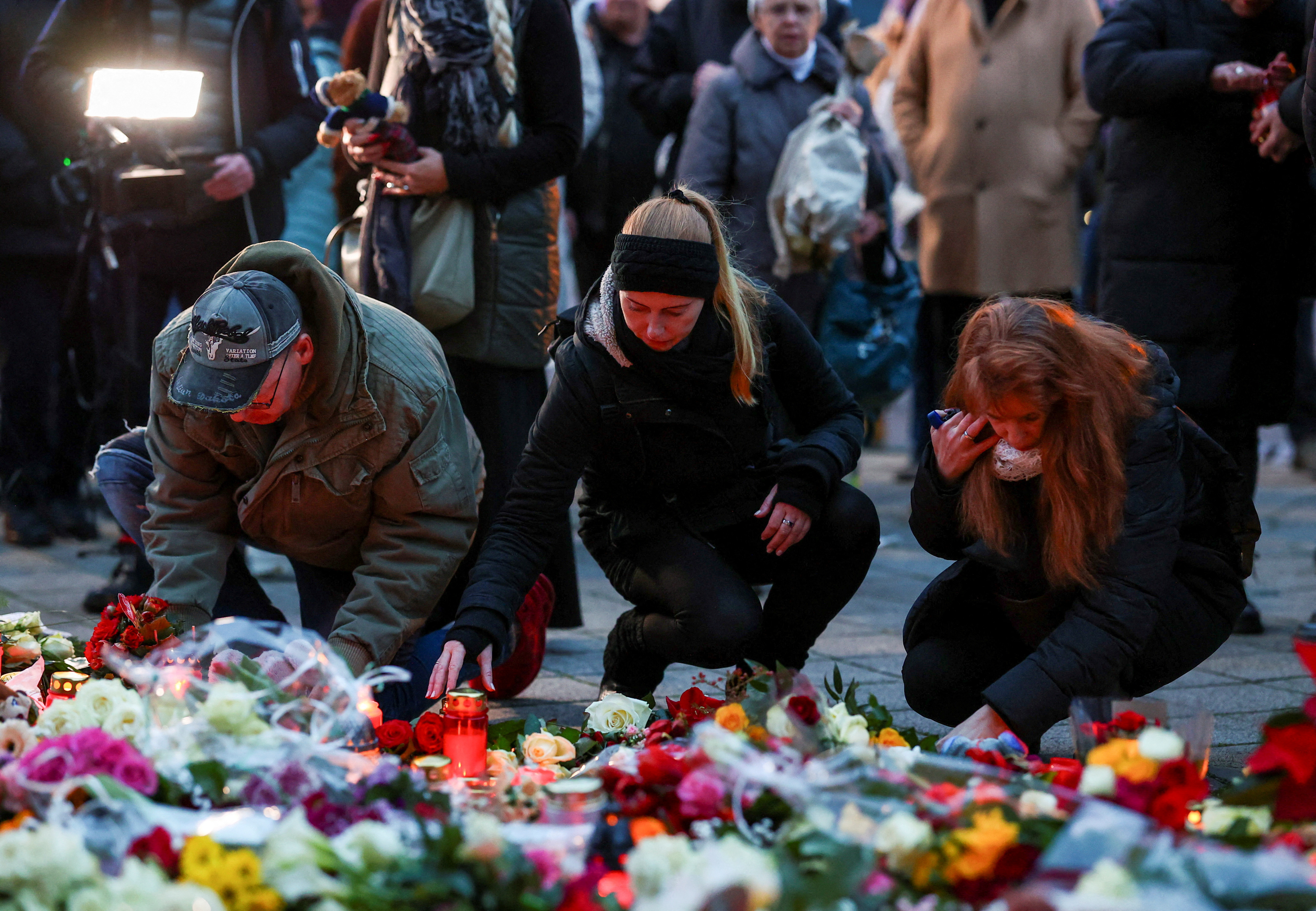 People lay candles and tributes at the site where a car drove into a crowd at a Magdeburg Christmas market in Magdeburg