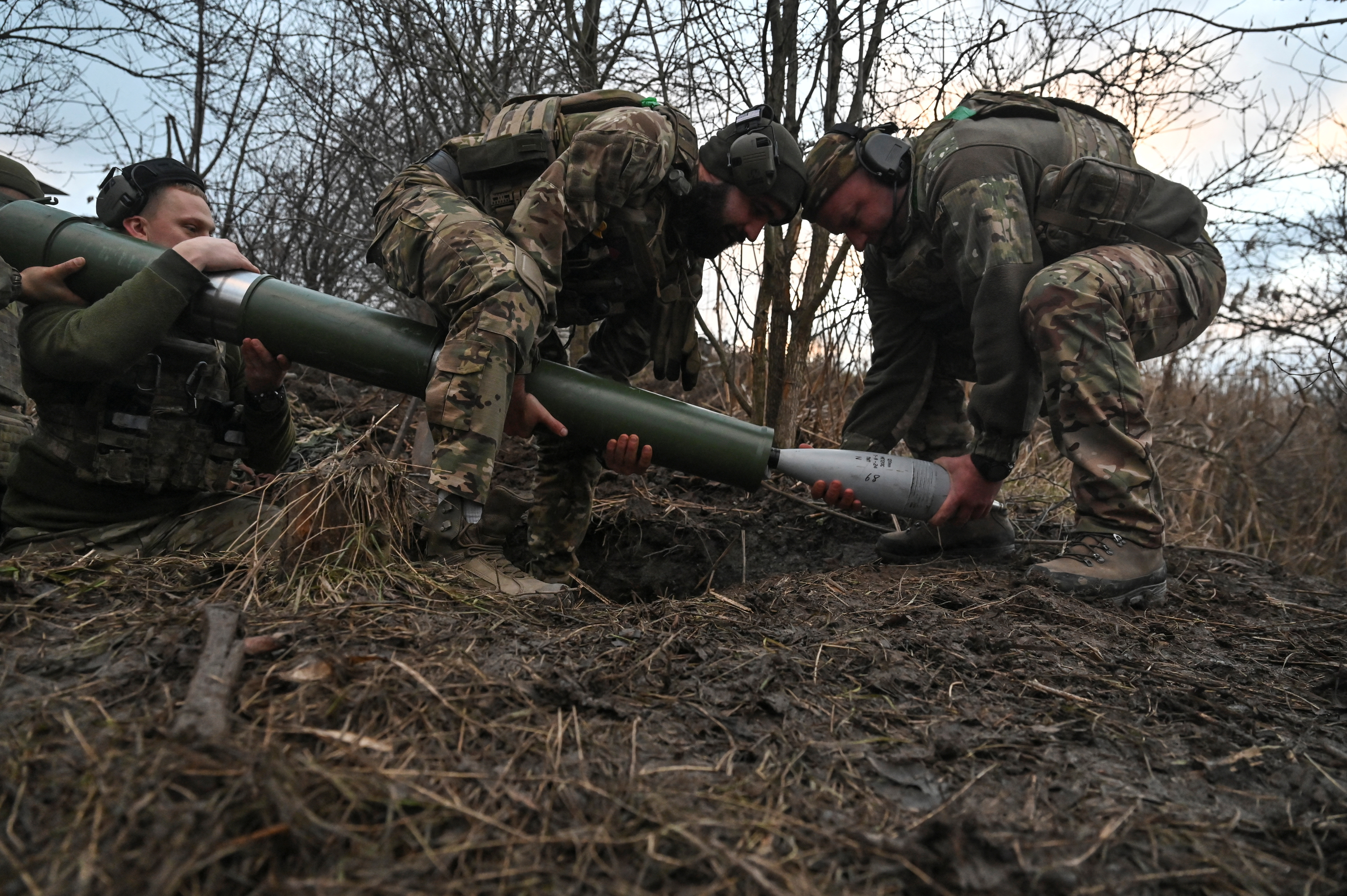 Members of the Сonsolidated Brigade 'Khyzhak' (Predator) of the Ukrainian Patrol Police Department extract a shell from a mortar during fire towards Russian troops at their position in a front line near the town of Toretsk, amid Russia's attack on Ukraine, in Donetsk region, Ukraine December 20, 2024. REUTERS/Stringer