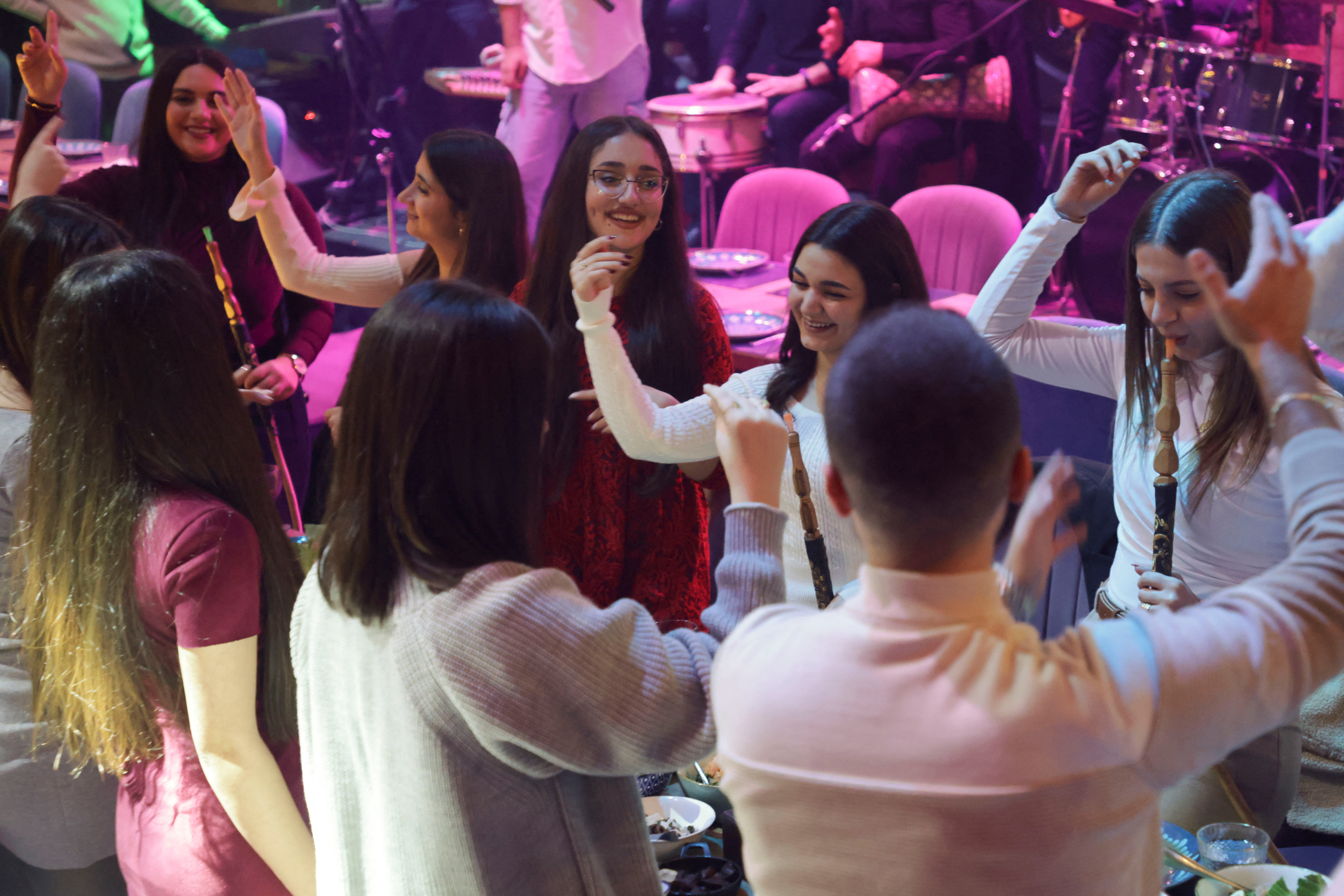 People gesture as they gather on Christmas day at a restaurant in Damascus, after the ousting of Syria's Bashar al-Assad, Syria, December 25
