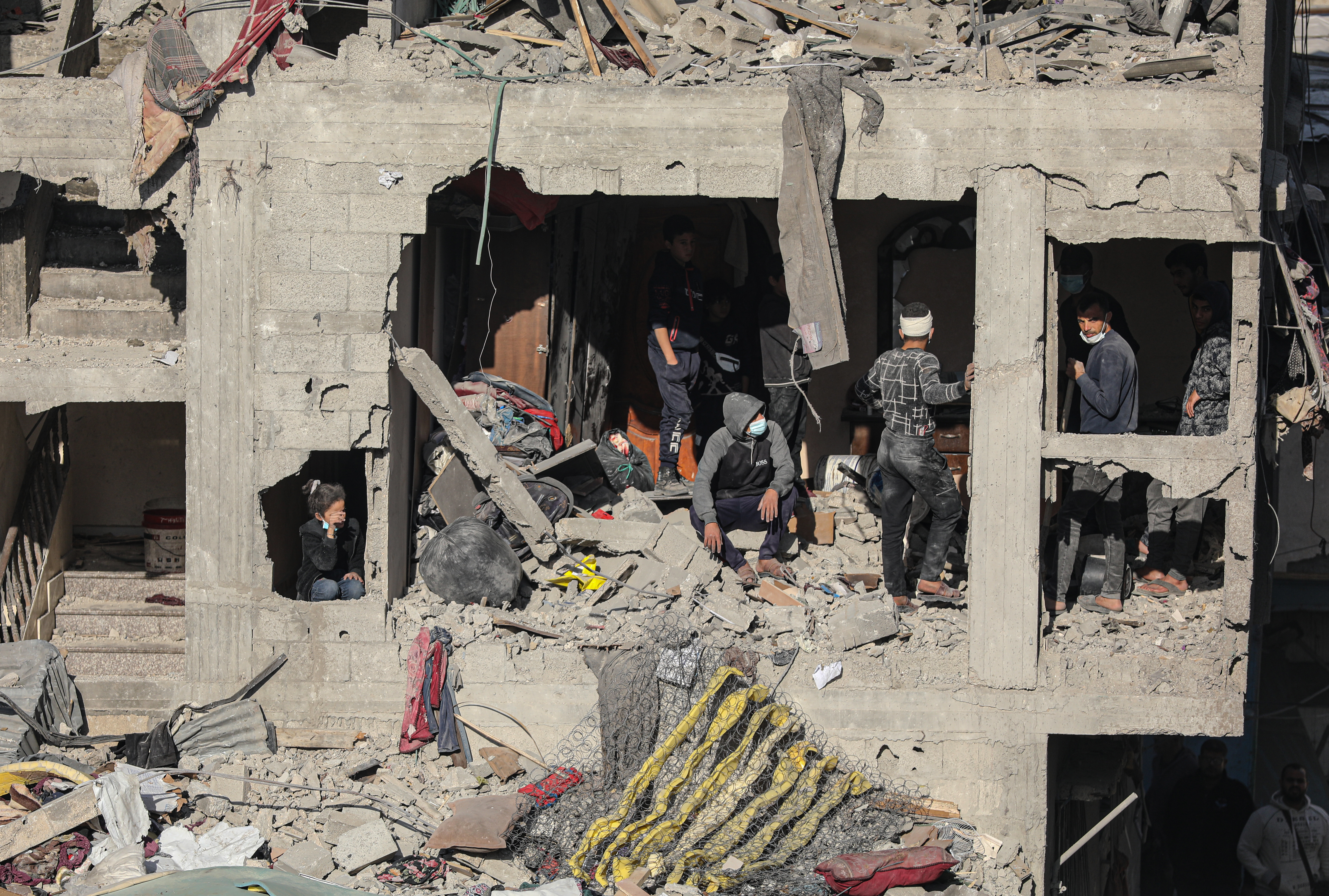 Palestinian residents inspect the targeted building and the damaged structures around it after the Israeli army attack on the house of the Zaytouniye family in Derec neighborhood in Gaza City, Gaza on December 19