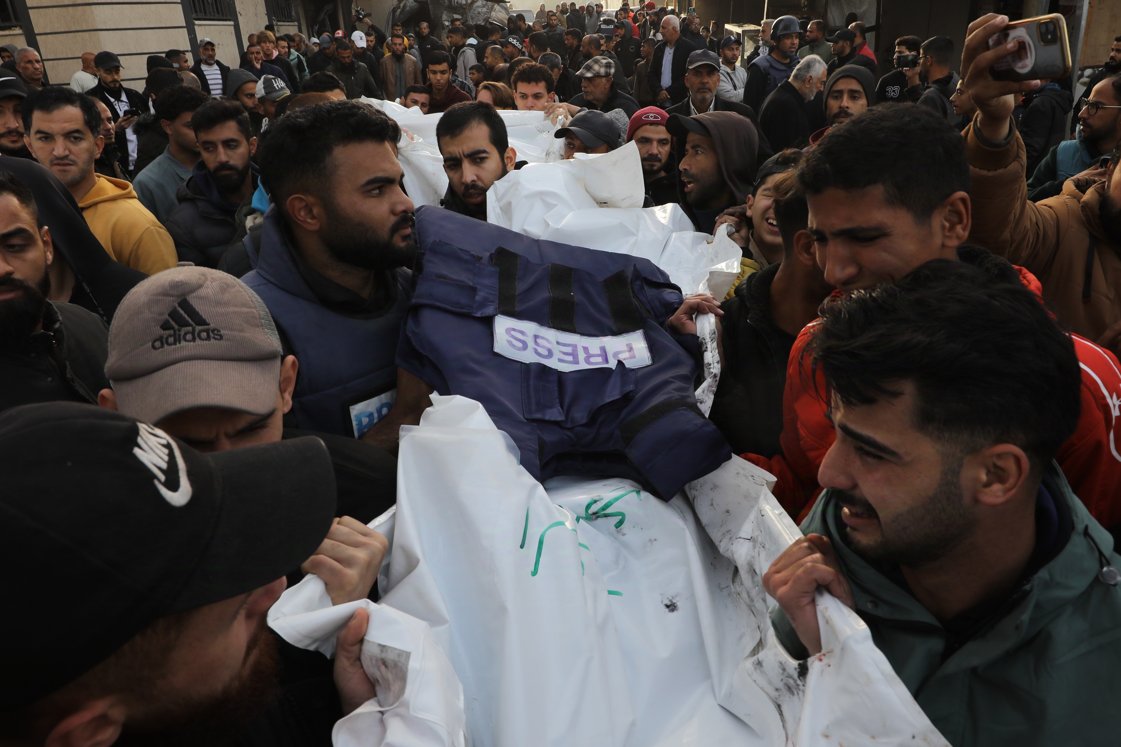 Relatives of 5 photojournalists Ayman al-Jedy and journalists Faisal Abu Al Qumsan, Ibrahim Sheikh Ali, Mohammad Al-Lada and Fadi Hassouna, who lost their lives after Israeli forces hit the live broadcasting vehicle belonging to Al-Quds al-Youm television (alqudstoday-tv) at the Nuseirat Refugee Camp, mourn as they hold funeral ceremony for them at Al Awda Hospital in Gaza City, Gaza on December 26
