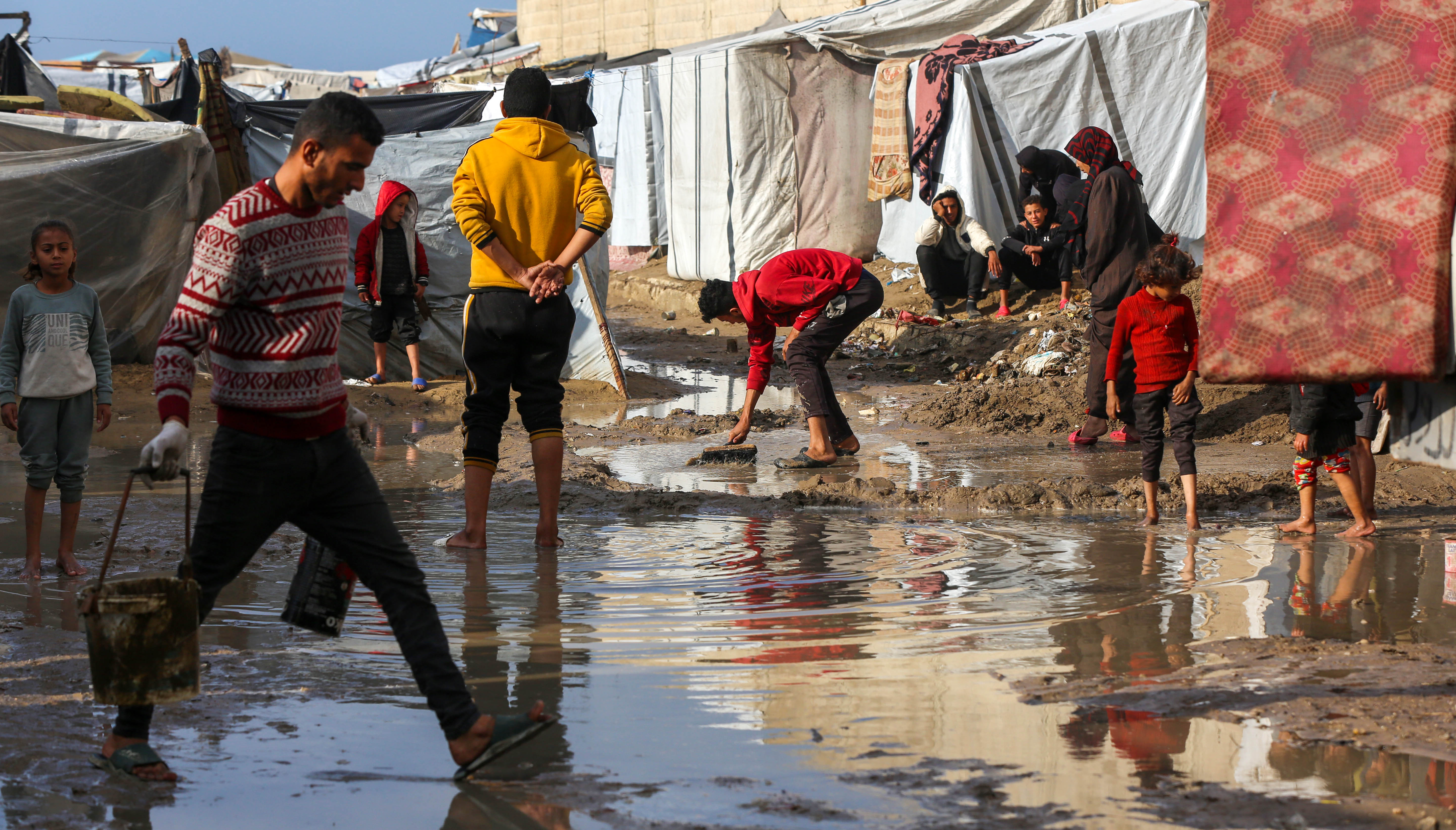 Palestinians taking shelter in tent camps are battling harsh weather conditions as heavy rainfall has flooded their tents on December 30