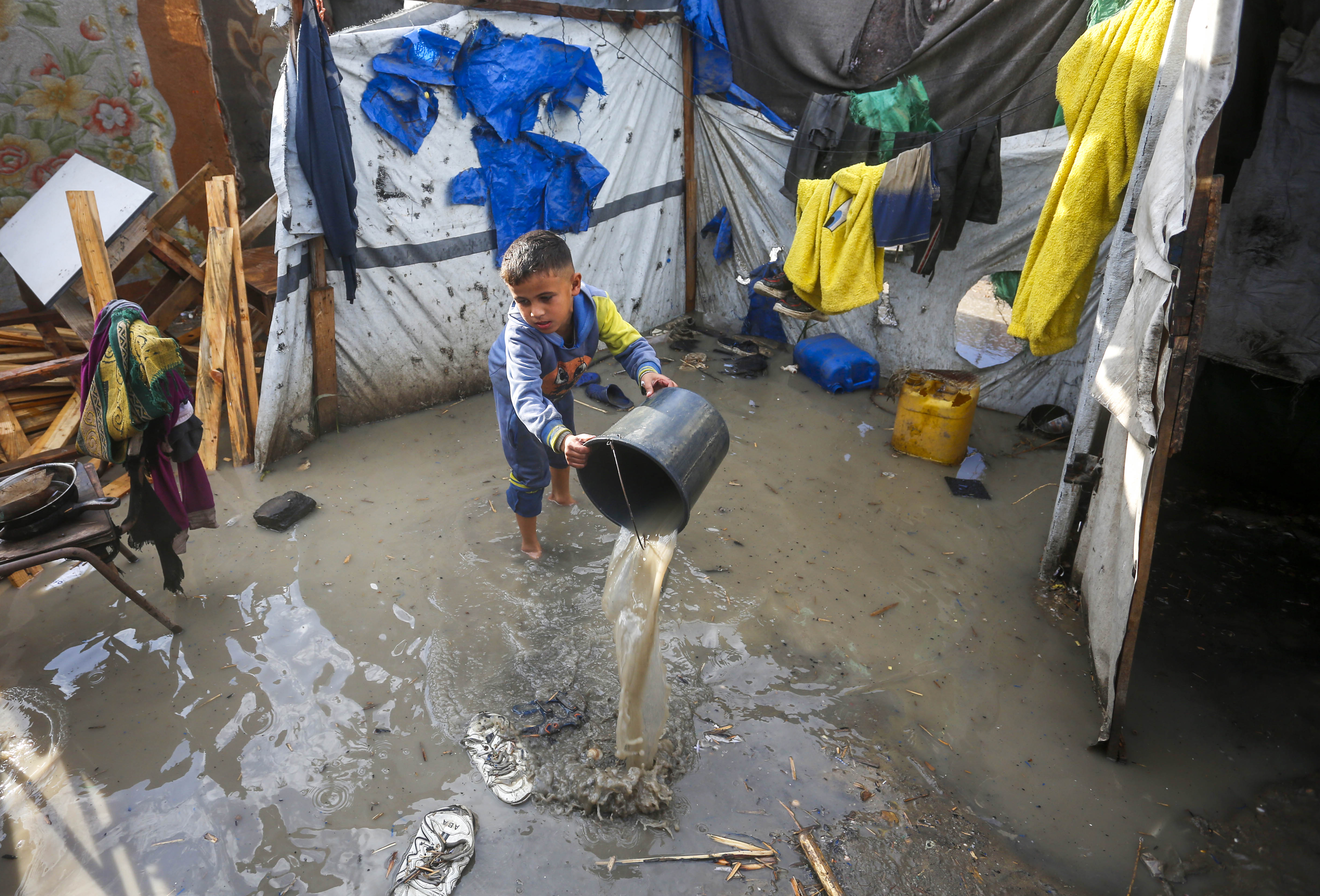 Palestinians taking shelter in tent camps are battling harsh weather conditions as heavy rainfall has flooded their tents on December 30, 2024 in Deir al-Balah