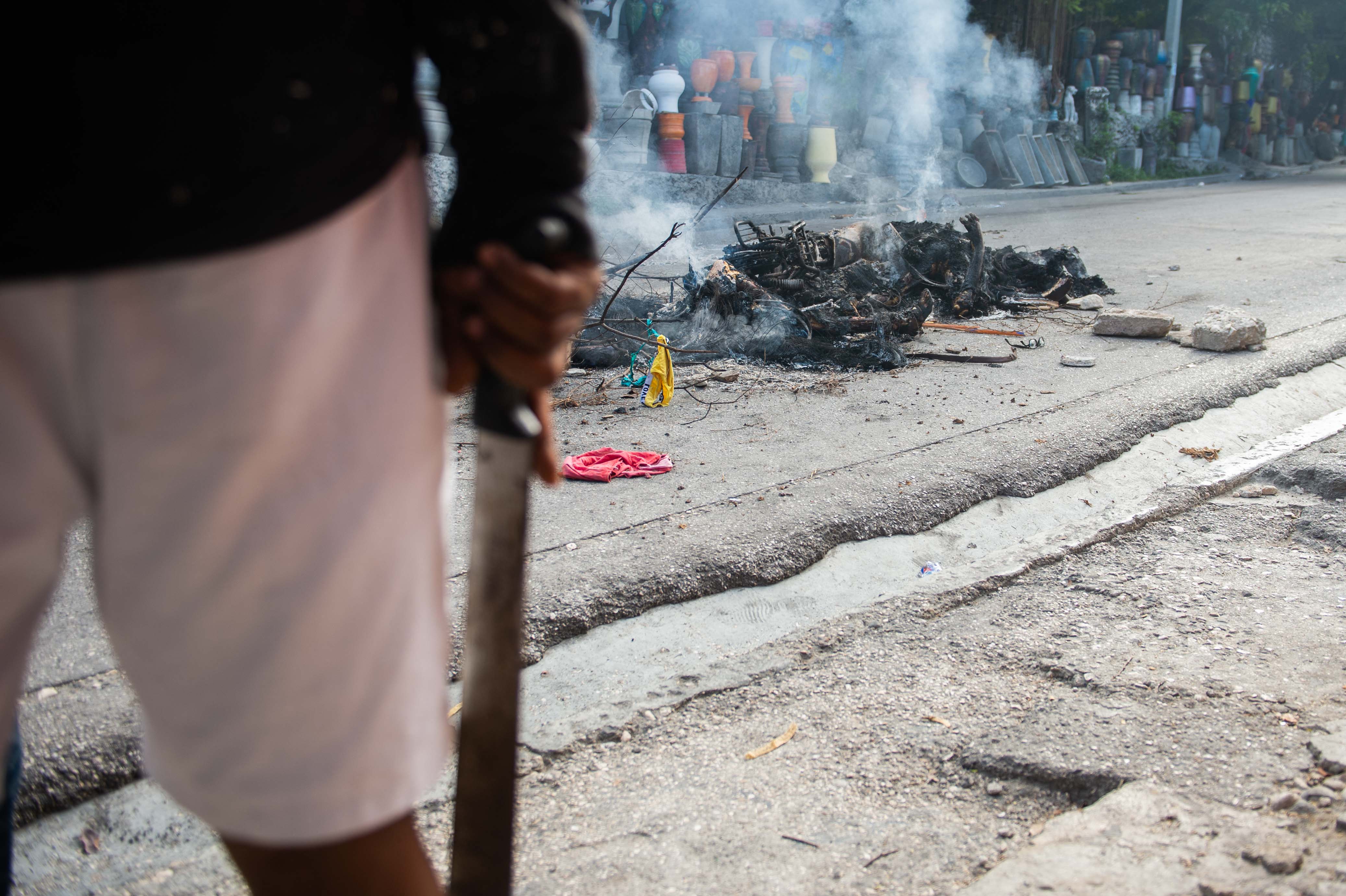 Graphic content / The smoldering remains of the bodies of alleged gang members lay in the street in Petion-Ville, a suburb of Port-au-Prince