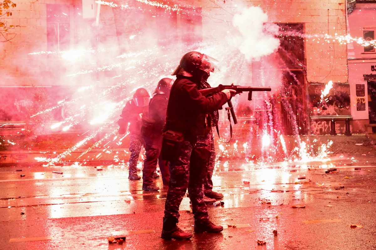 Fireworks shot by protesters explode near police in riot gear firing tear gas during a fourth day of nationwide protests