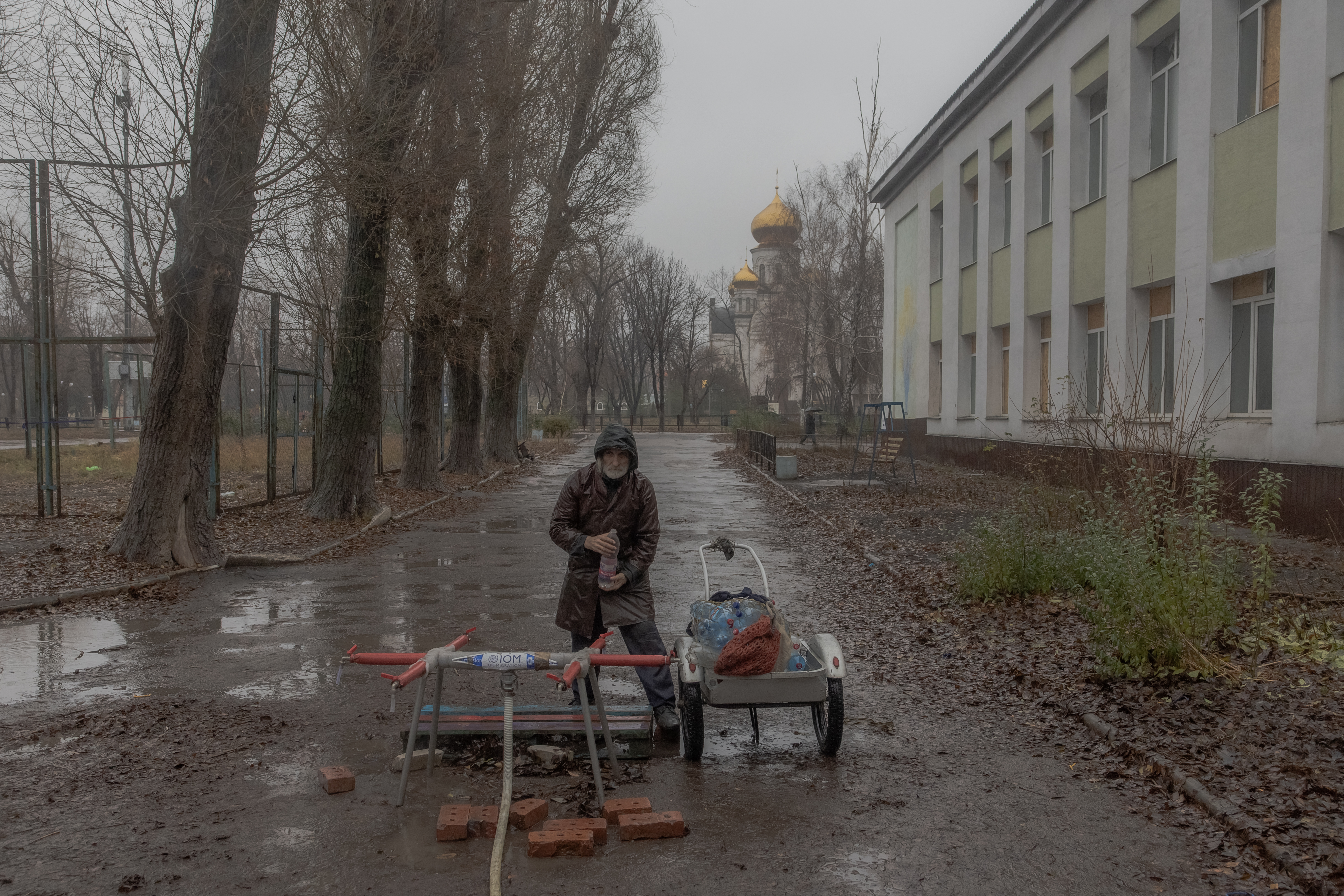 A resident fills bottles with water on a street in Pokrovsk, the eastern Donetsk region, on Wednesday