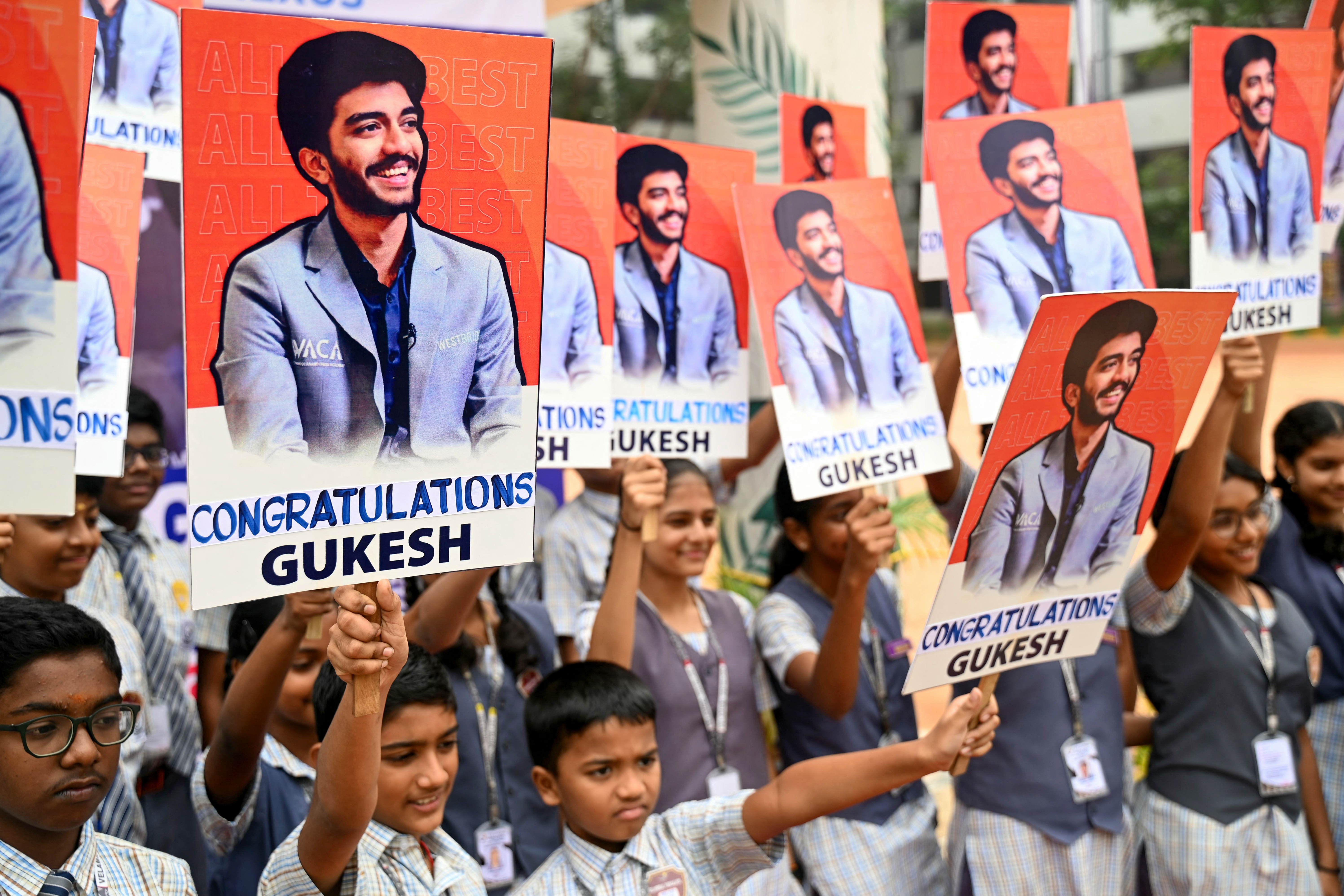 Indian school students congratulate the world's youngest chess champion Gukesh Dommaraju, in Chennai on December 13, 2024.