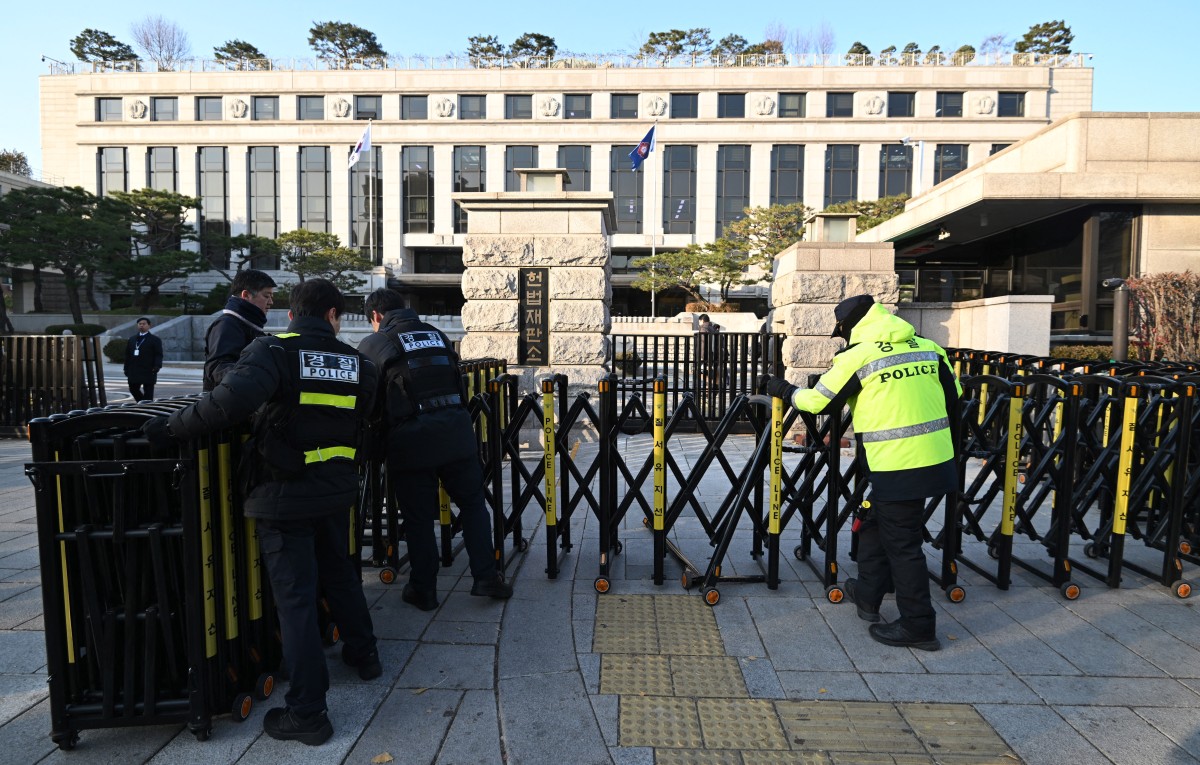Policemen set up barricades in front of the Constitutional Court in Seoul on December 16, 2024, as the court is set to hold its first meeting of its justices to review the parliamentary impeachment of President Yoon Suk Yeol. South Korea's constitutional court began proceedings on December 16 for for the impeachment of President Yoon Suk Yeol, who has been suspended from office over his failed bid to impose martial law. (Photo by JUNG YEON-JE / AFP) Related content