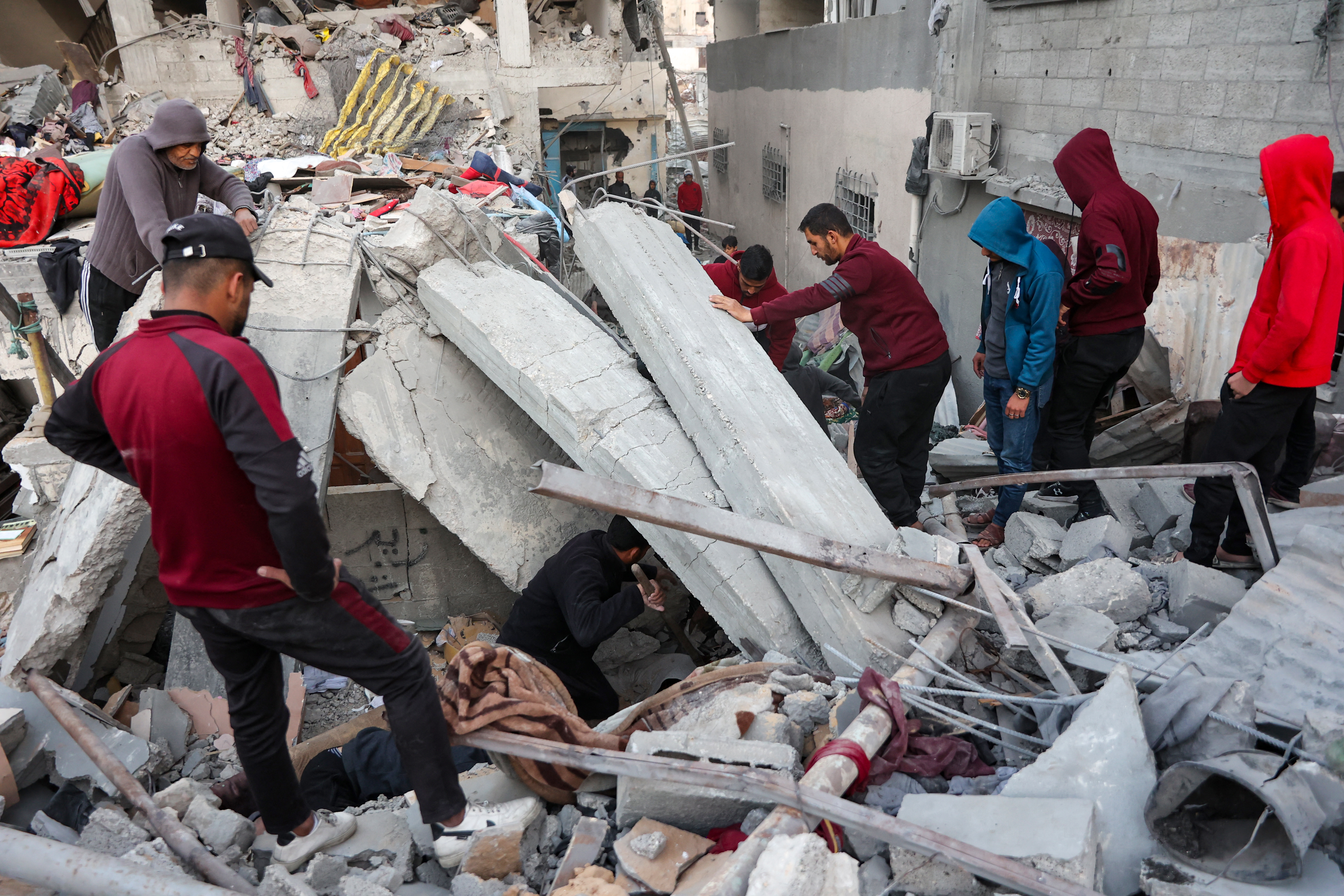 People look for survivors following an Israeli strike on a home belonging to the al-Zaytouniyah family, in the al-Daraj neighbourhood in Gaza City, in the central Gaza Strip on December 19