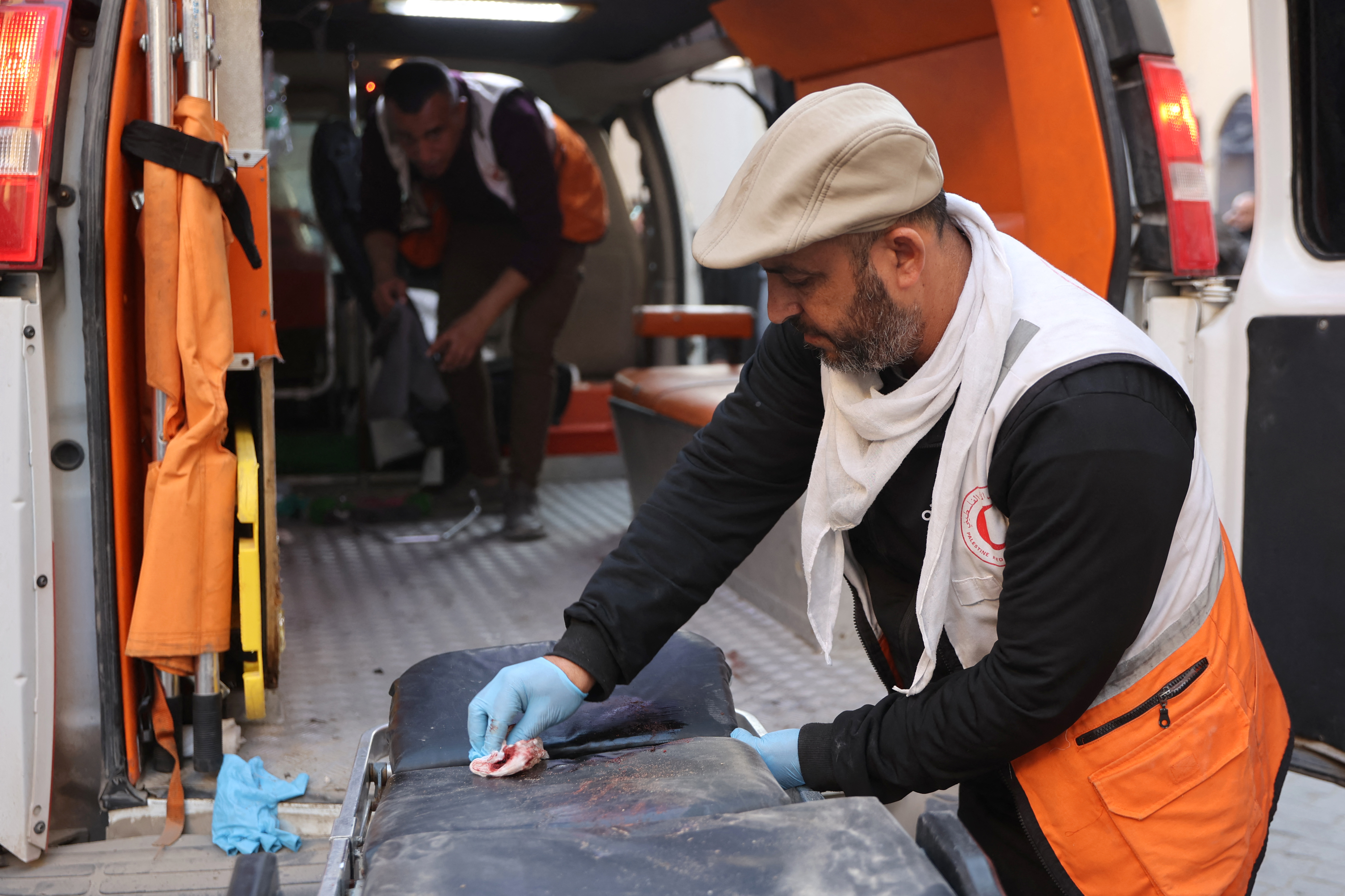A Palestinian paramedic cleans blood from a gurney at Al-Ahli Arab hospital, also known as the Baptist hospital, in Gaza City on December 19