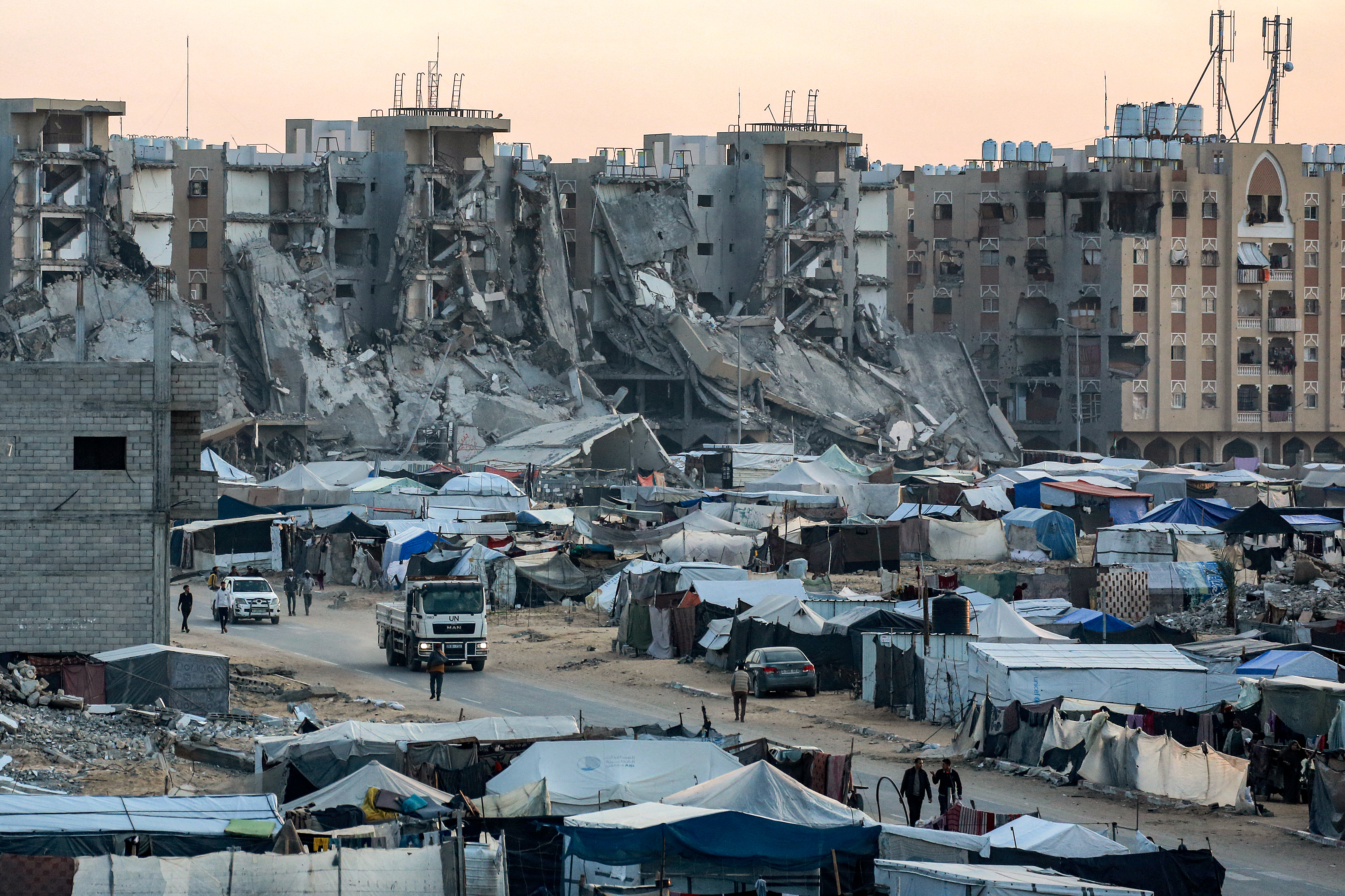 Tents sheltering Palestinians displaced by conflict are pictured near destroyed buildings
