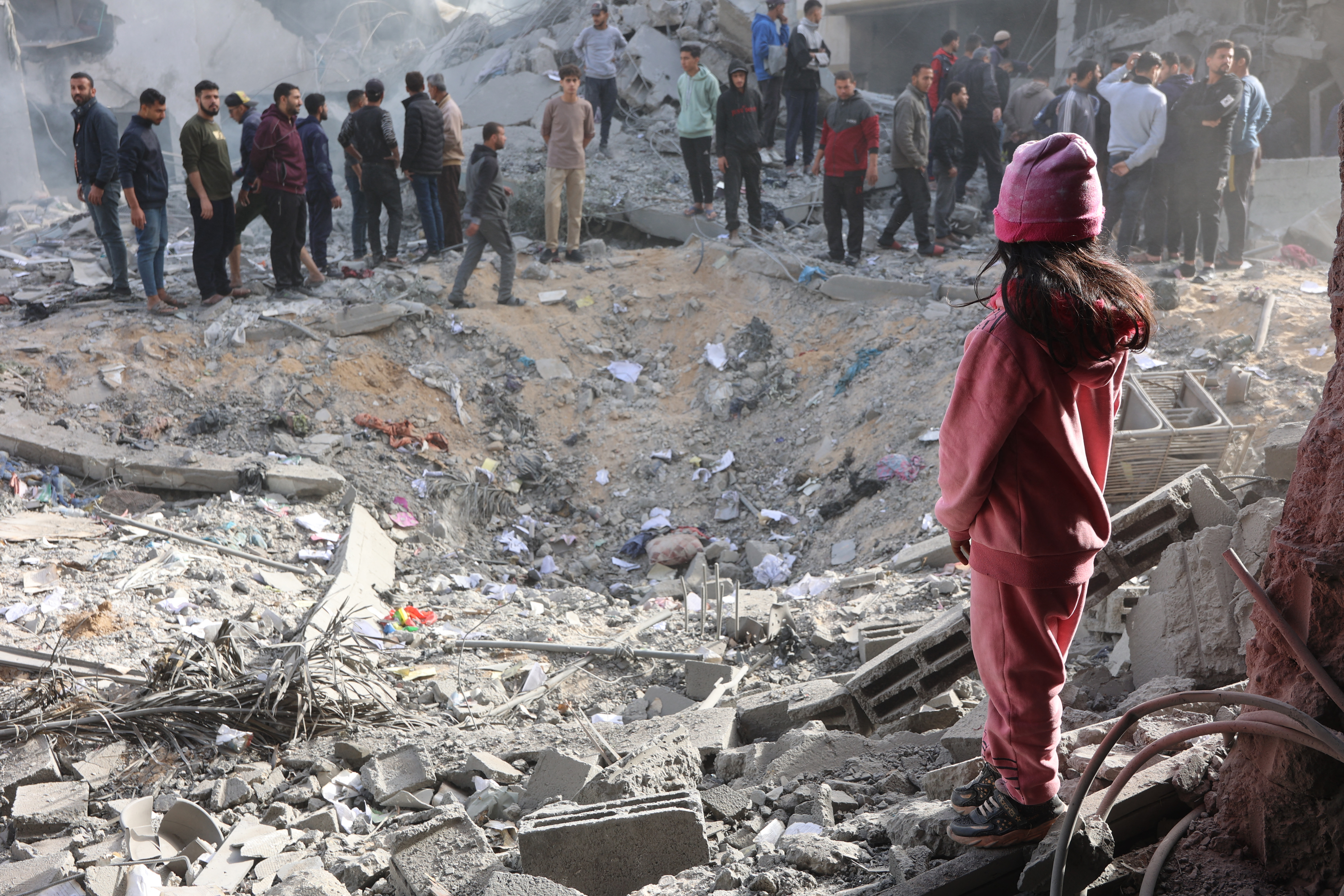 Civilians check the site of an Israeli strike in a residential area in the Tuffah neighbourhood, east of Gaza City, on December 26