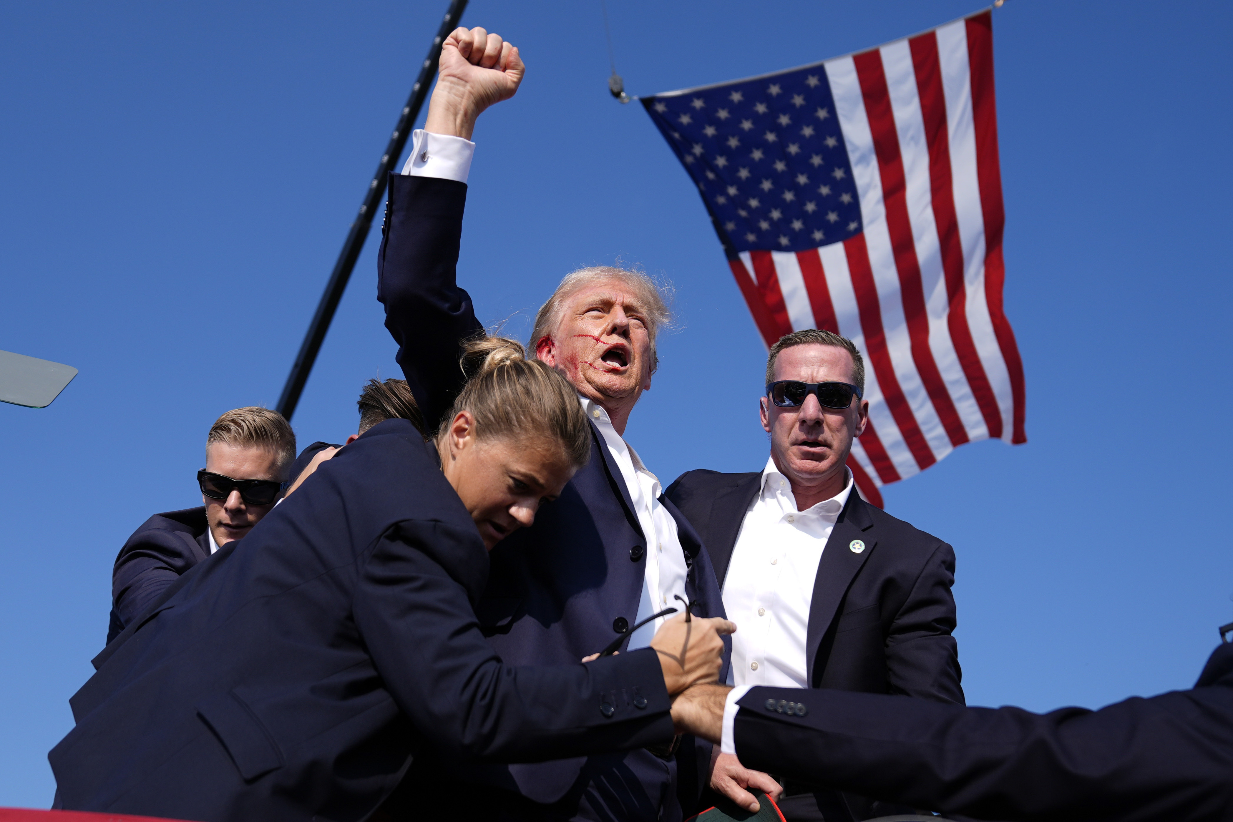 Republican presidential candidate former President Donald Trump is surrounded by U.S. Secret Service agents after an assassination attempt at a campaign rally in Butler, Pa., July 13