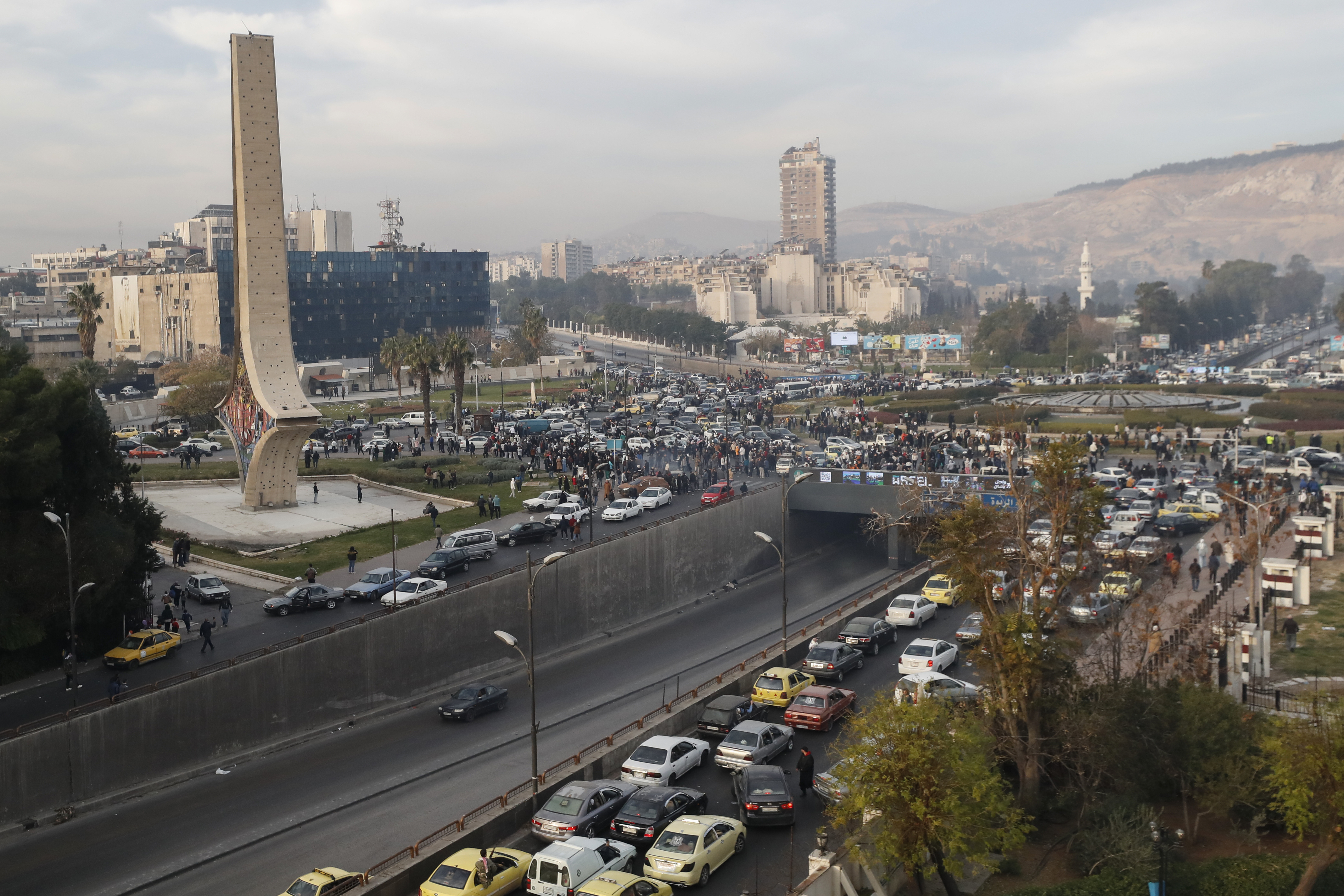 Syrians gather as they celebrate the arrival of opposition fighters in Damascus