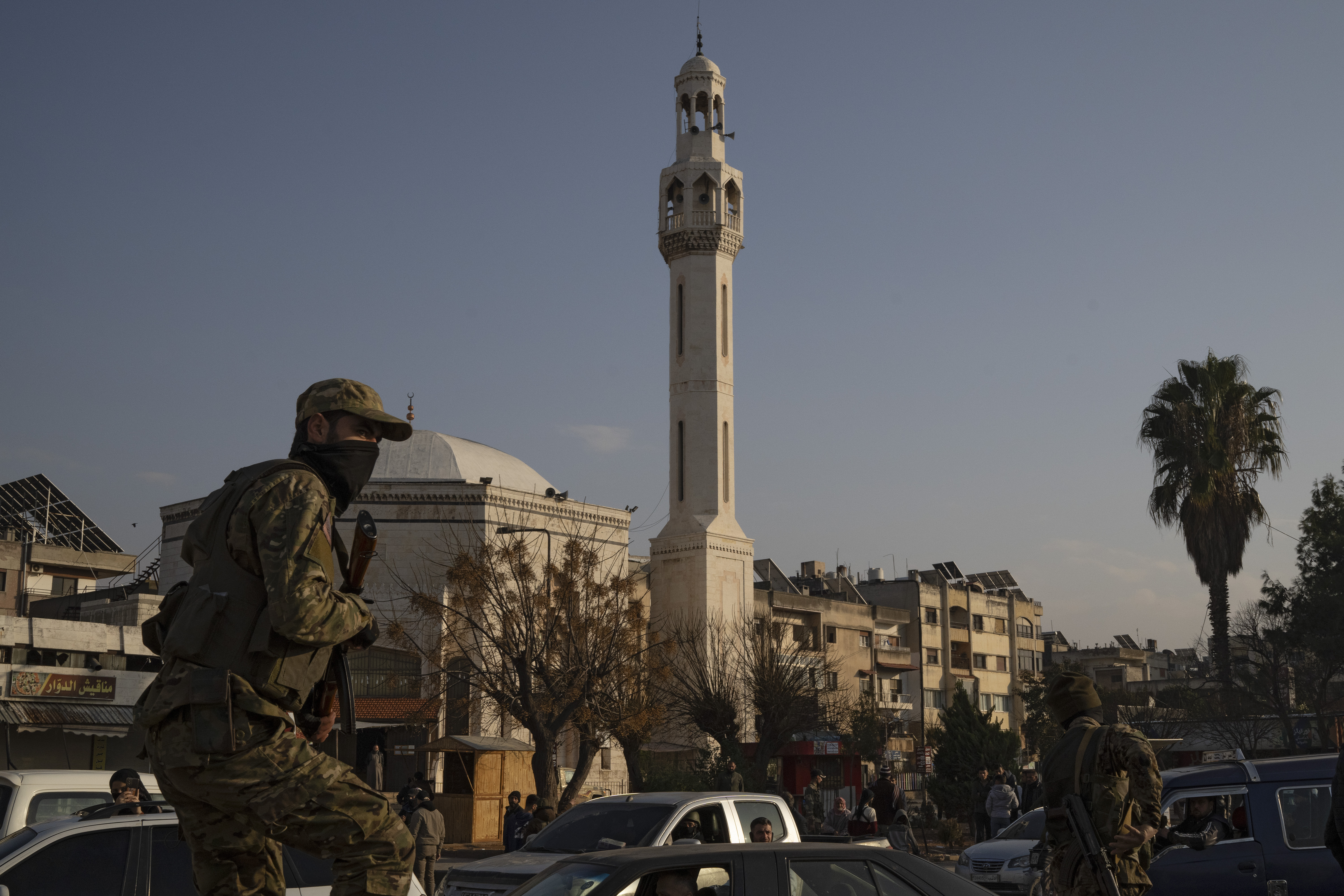 A member of the security forces of the newly formed Syrian government patrols an area near to a security checkpoint in Homs, Syria, Thursday, Dec. 26