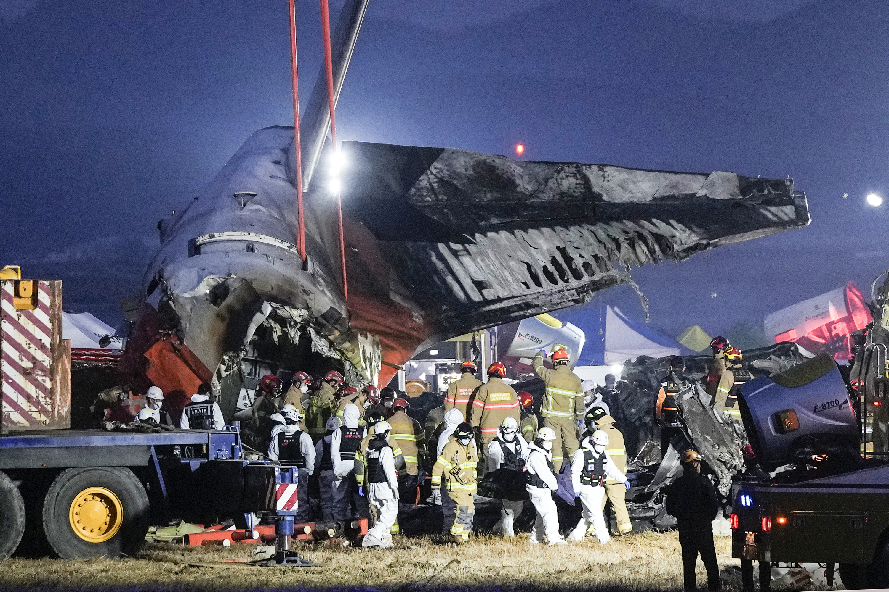 Rescue team carry the body of a passenger at the site of a plane fire at Muan International Airport in Muan